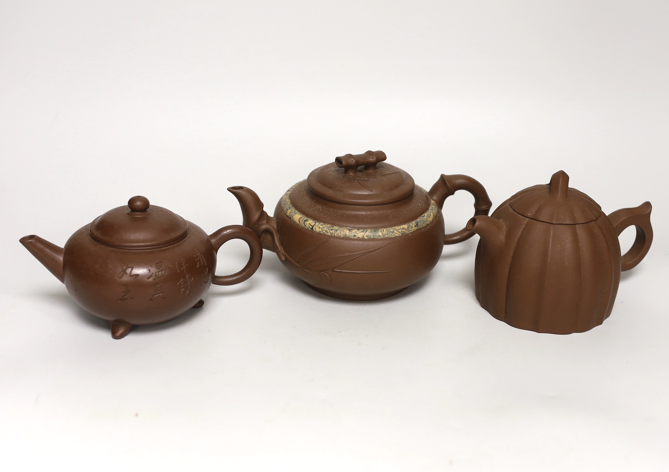 Three Chinese Yixing dark brown zisha clay teapots, one with marbled clay band largest 12cm diam.                                                                                                                           