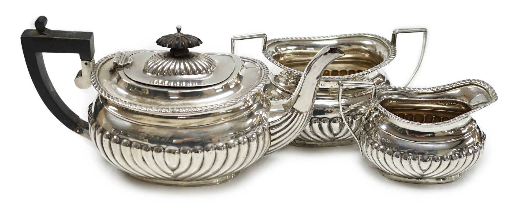 A George V demi fluted silver three piece bachelor's tea set, Jones & Crompton, Birmingham, 1913, gross weight 14.5oz.                                                                                                      