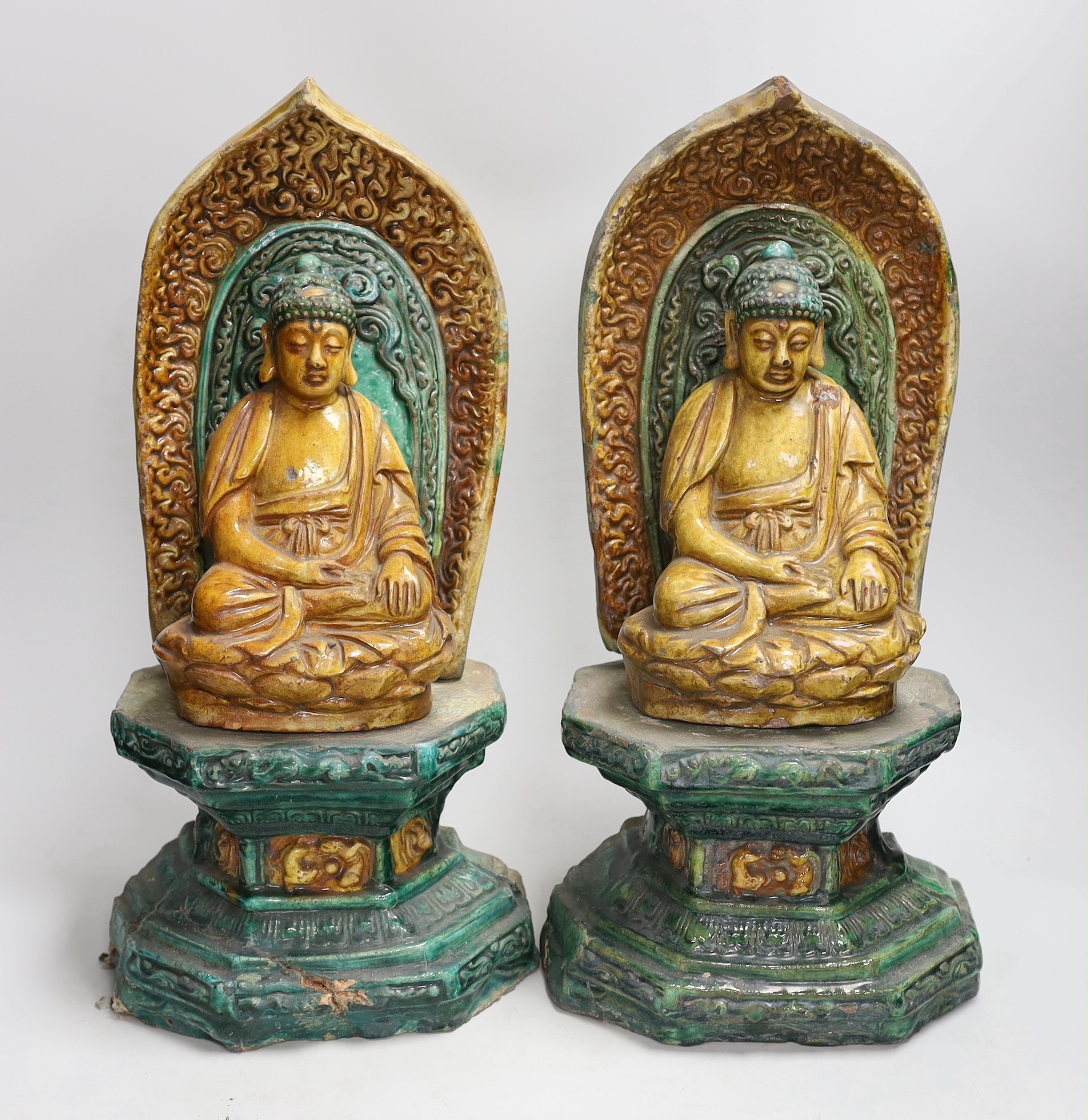 A pair of Chinese sancai glazed Buddha figures on shrines. 43cm tall                                                                                                                                                        