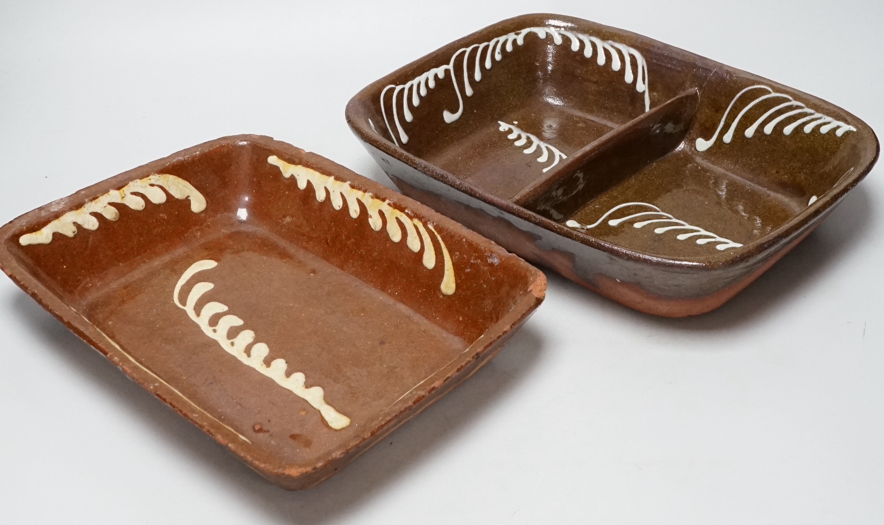 A 19th century slipware baking dish, 27cm wide, together with a twin division dish, 30cm                                                                                                                                    