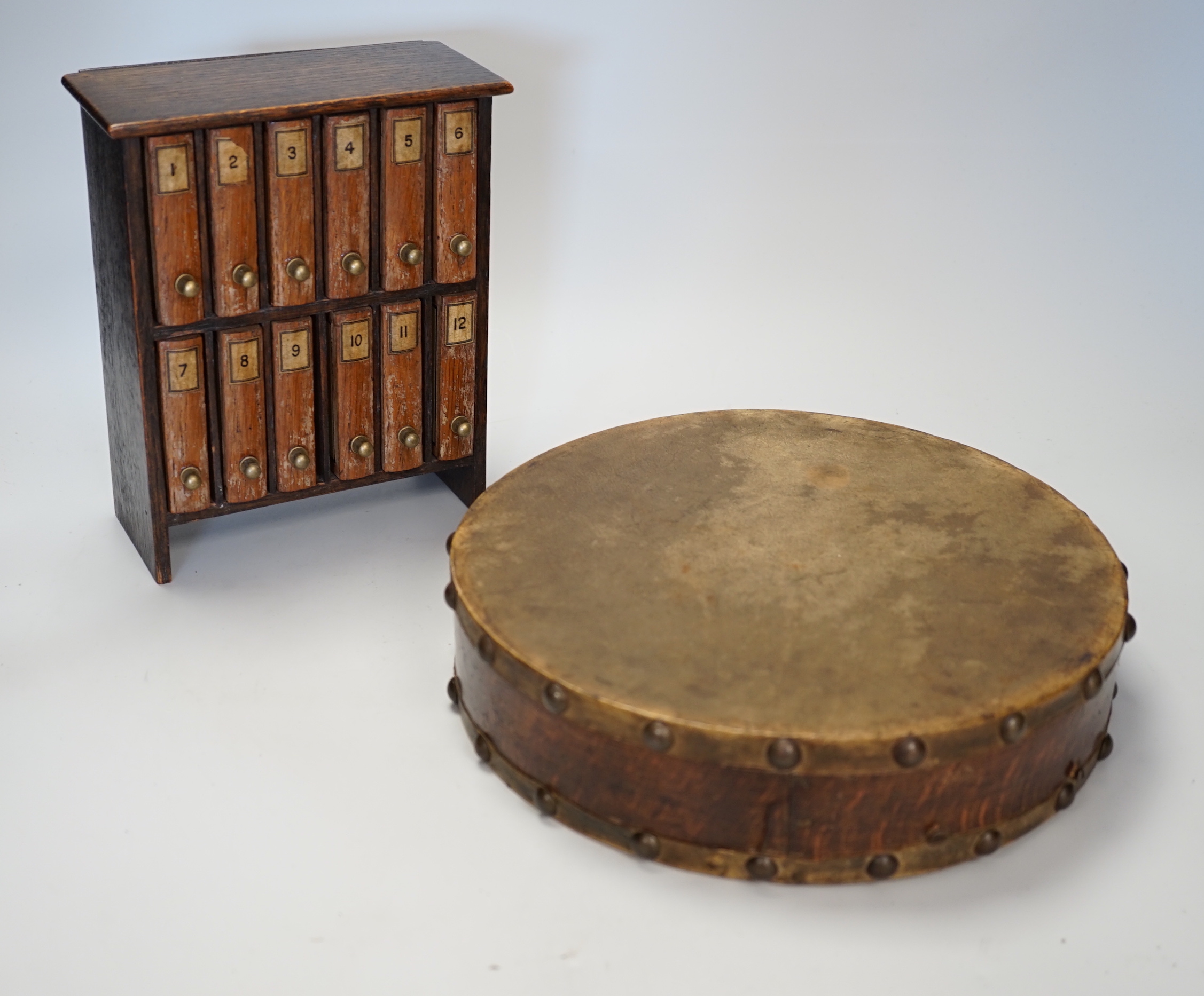 A French 'painted slide' game in the form of a miniature bookcase, 20cm high, and a double-sided tambourine with oak frame.                                                                                                 