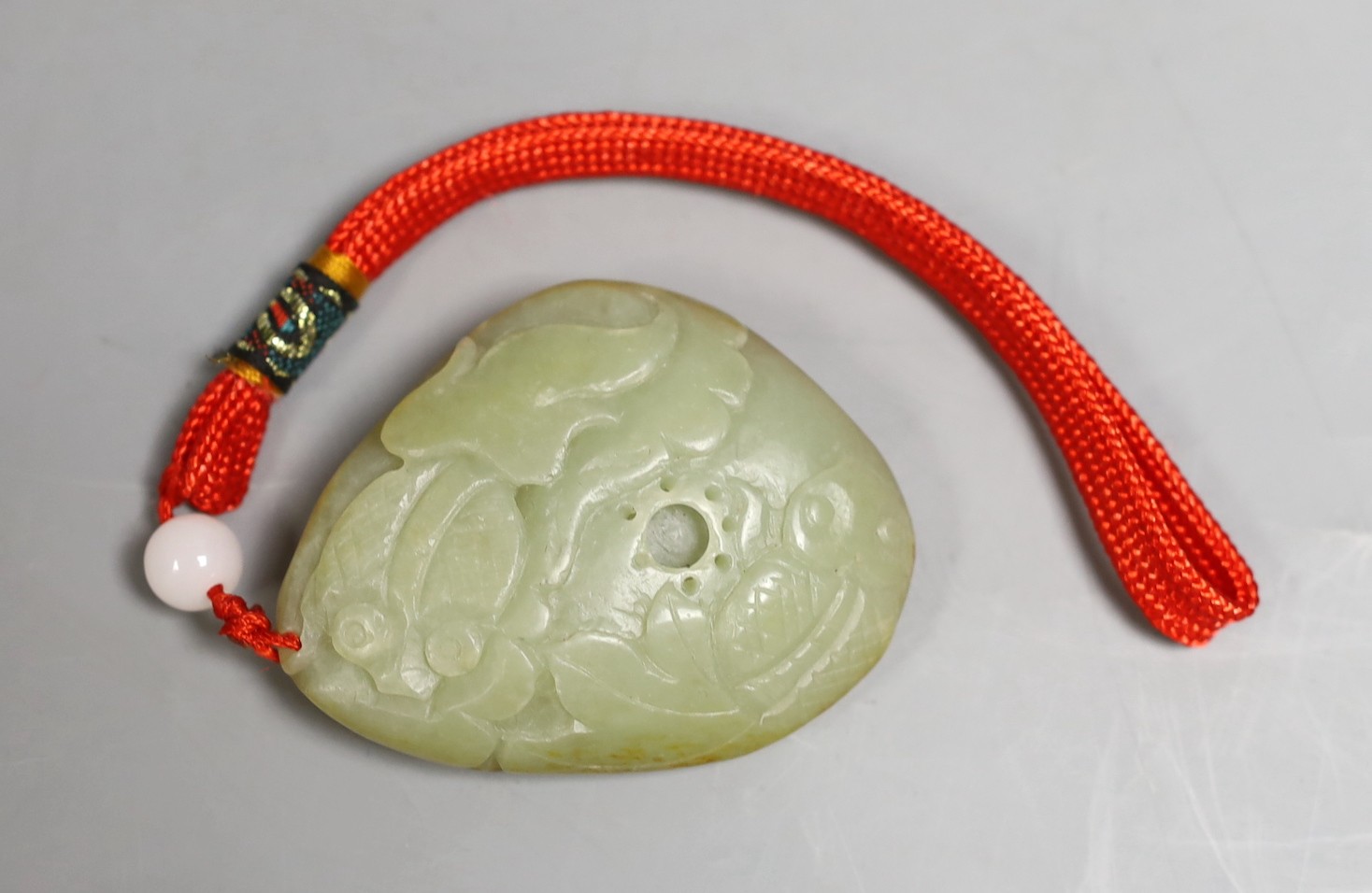 Chinese carved jade pendant of koi swimming among mid pondweed, 7cm tall                                                                                                                                                    