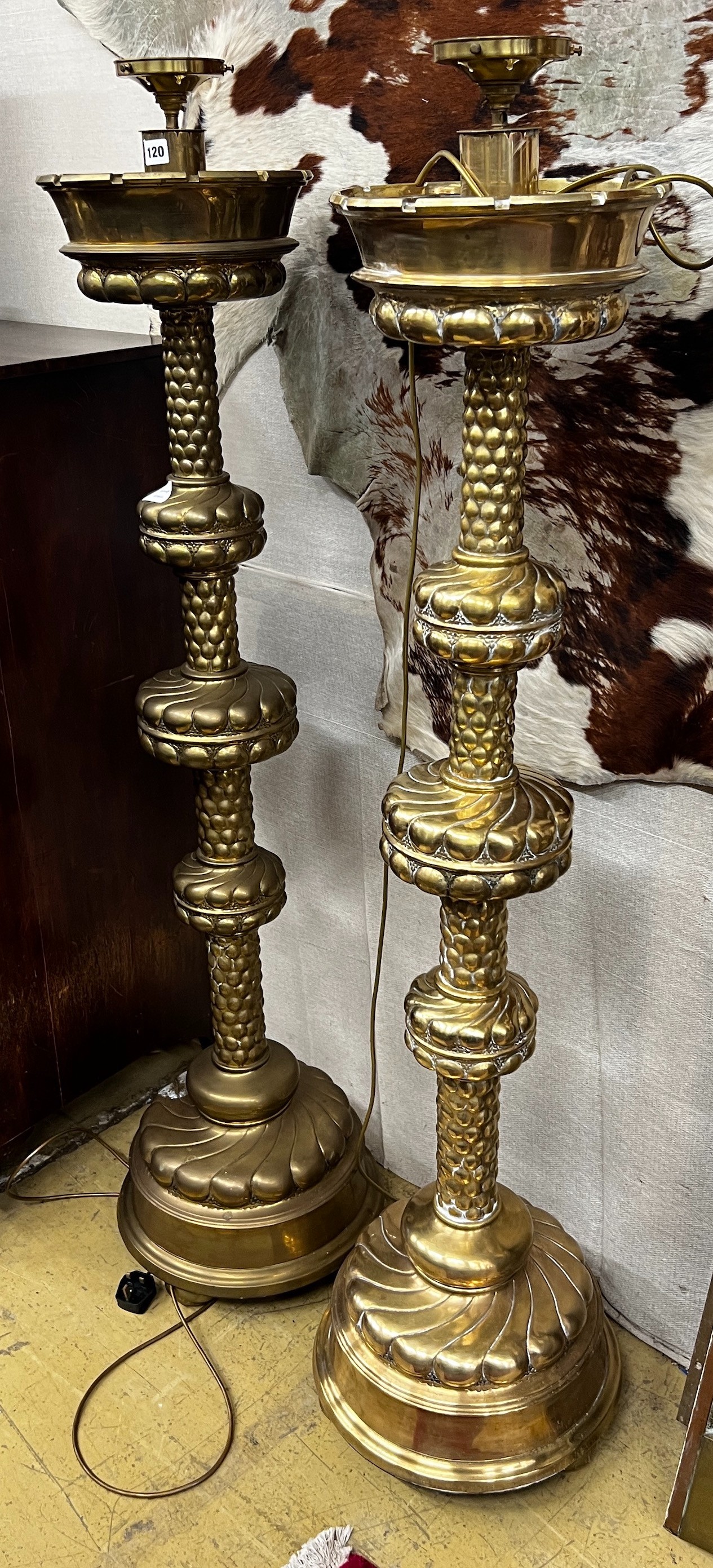 A pair of large Dutch embossed brass altar sticks converted to electricity, height 150cm                                                                                                                                    