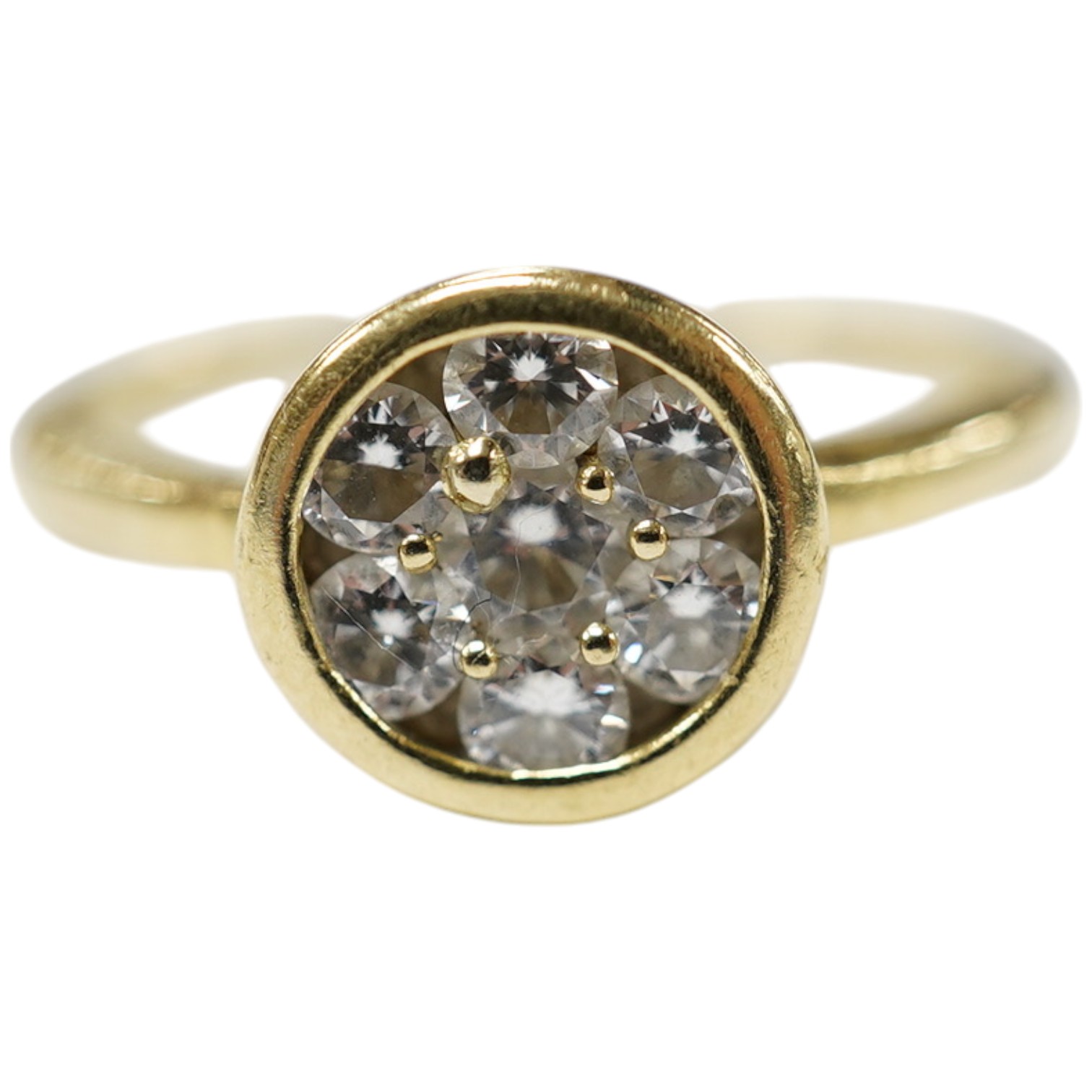 A yellow metal and seven stone diamond cluster set circular ring, size N/O, gross weight 3.4 grams. Condition - fair to good                                                                                                