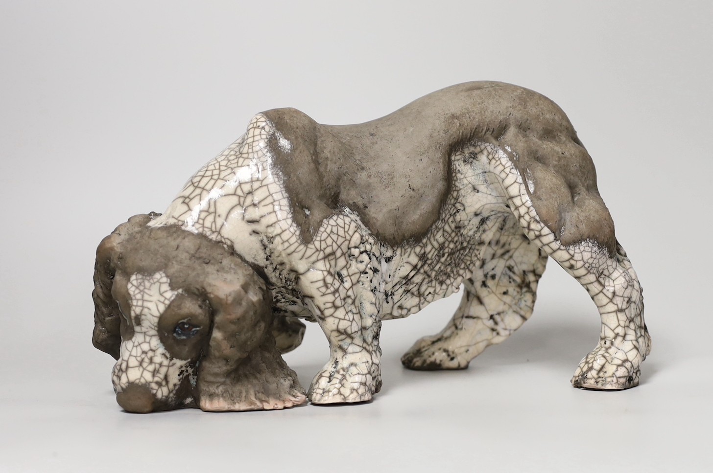 Keza Rudge (British 20th Century), a pottery model of a sniffing spaniel, signed. 29cm wide                                                                                                                                 