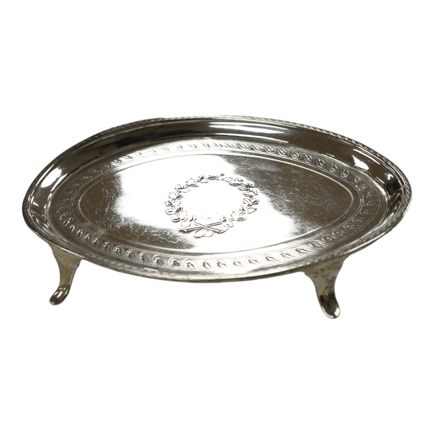 A George III engraved silver oval teapot stand, London, 1796, on four swept feet, 17.3cm, 137 grams. Condition - poor.                                                                                                      