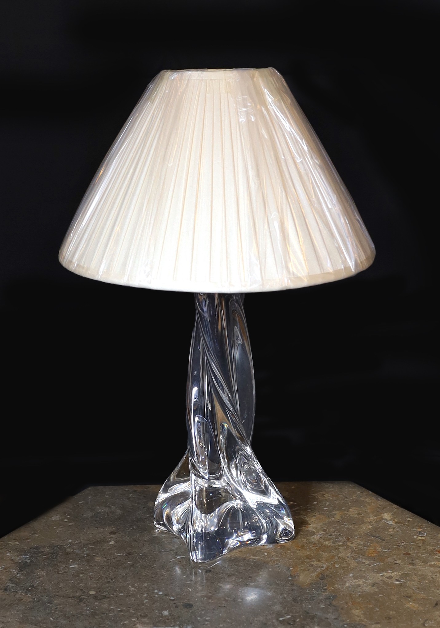 A 1960s Baccarat clear crystal glass table lamp, of twisted form, with replacement pleated silk shade, height 35cm                                                                                                          
