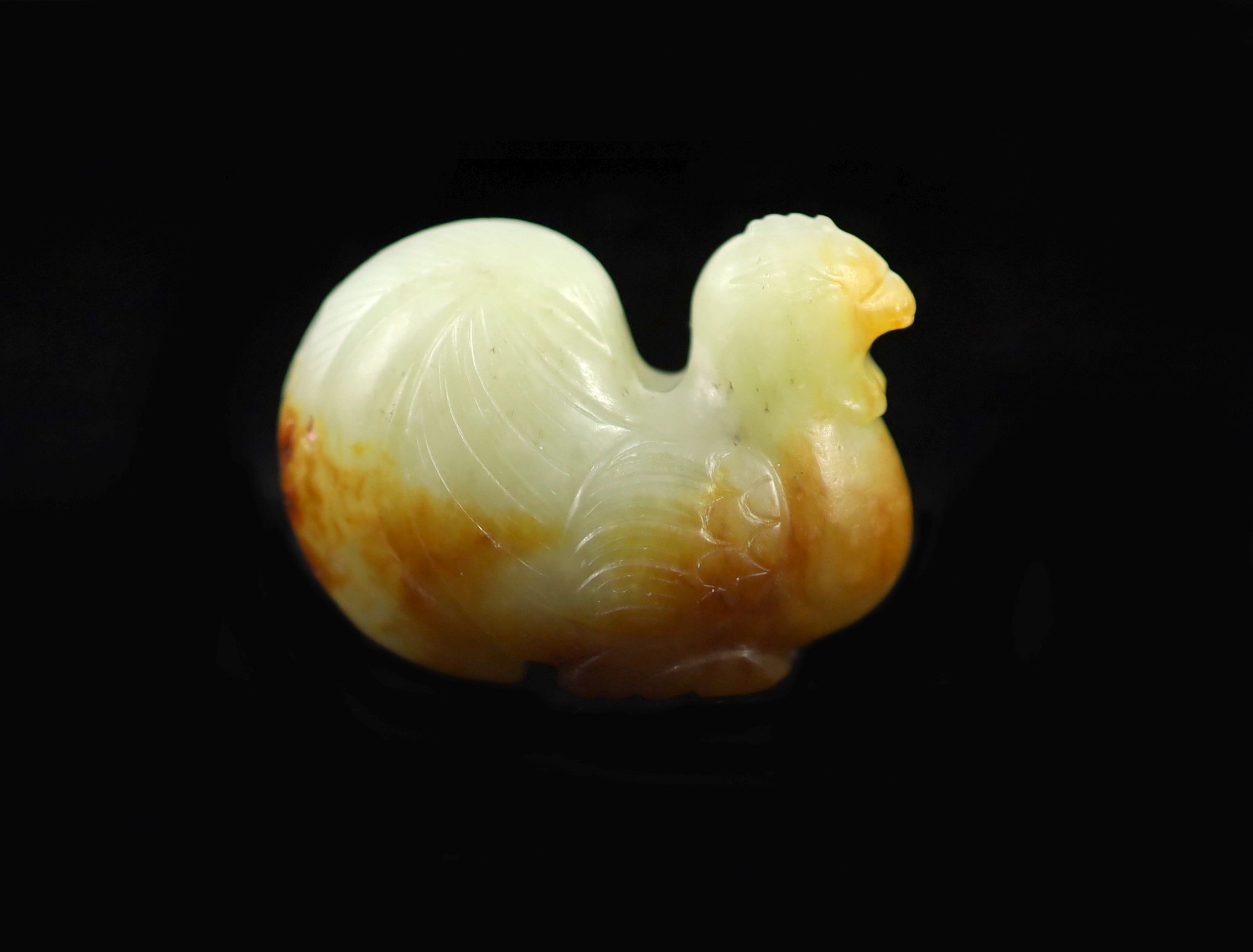 A Chinese pale celadon and russet jade ‘cockerel’ finial, 3.6 cm                                                                                                                                                            