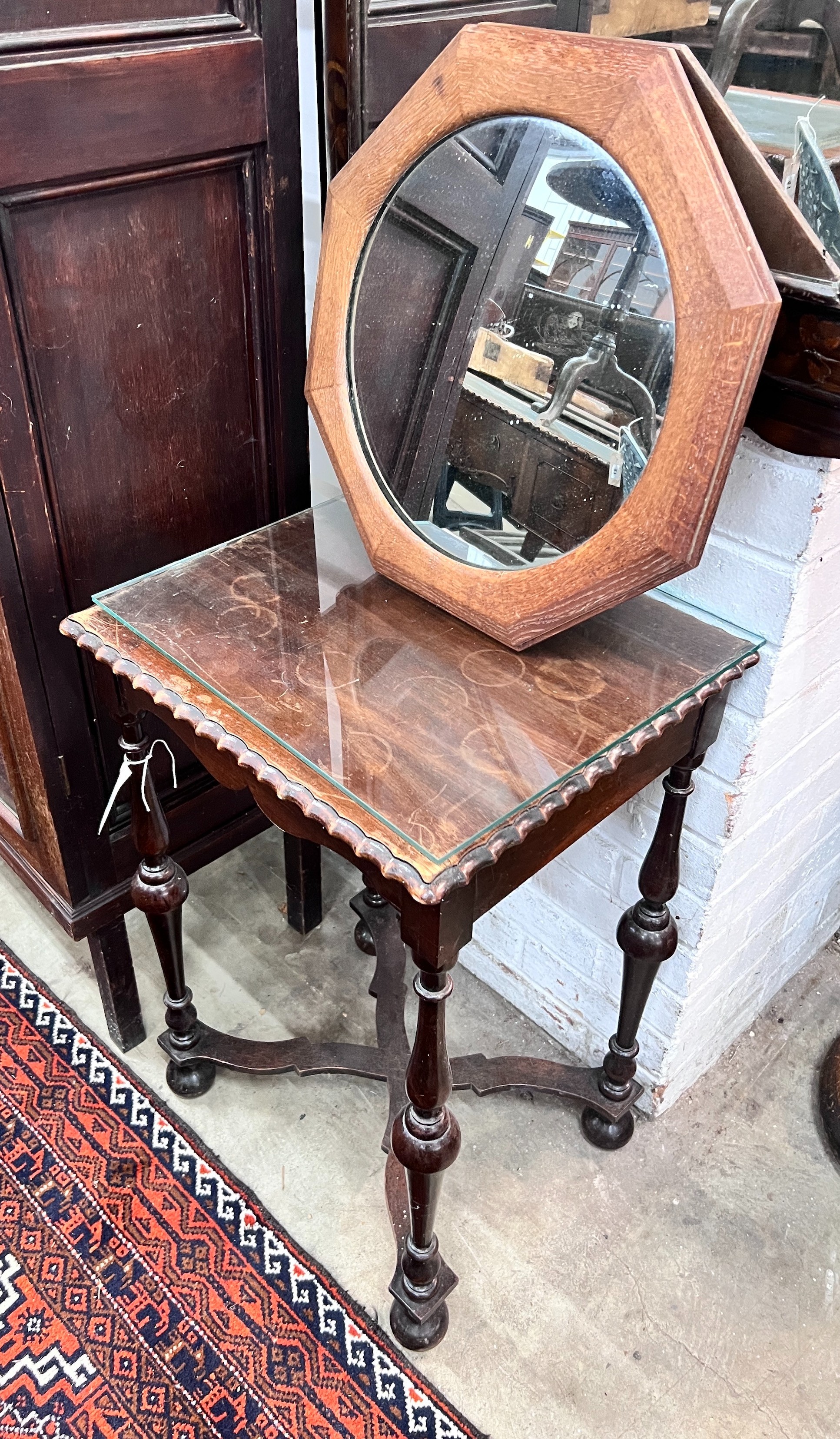 A 1920's mahogany side table, width 45cm, height 70cm, together with an octagonal oak framed wall mirror *Please note the sale commences at 9am.                                                                            