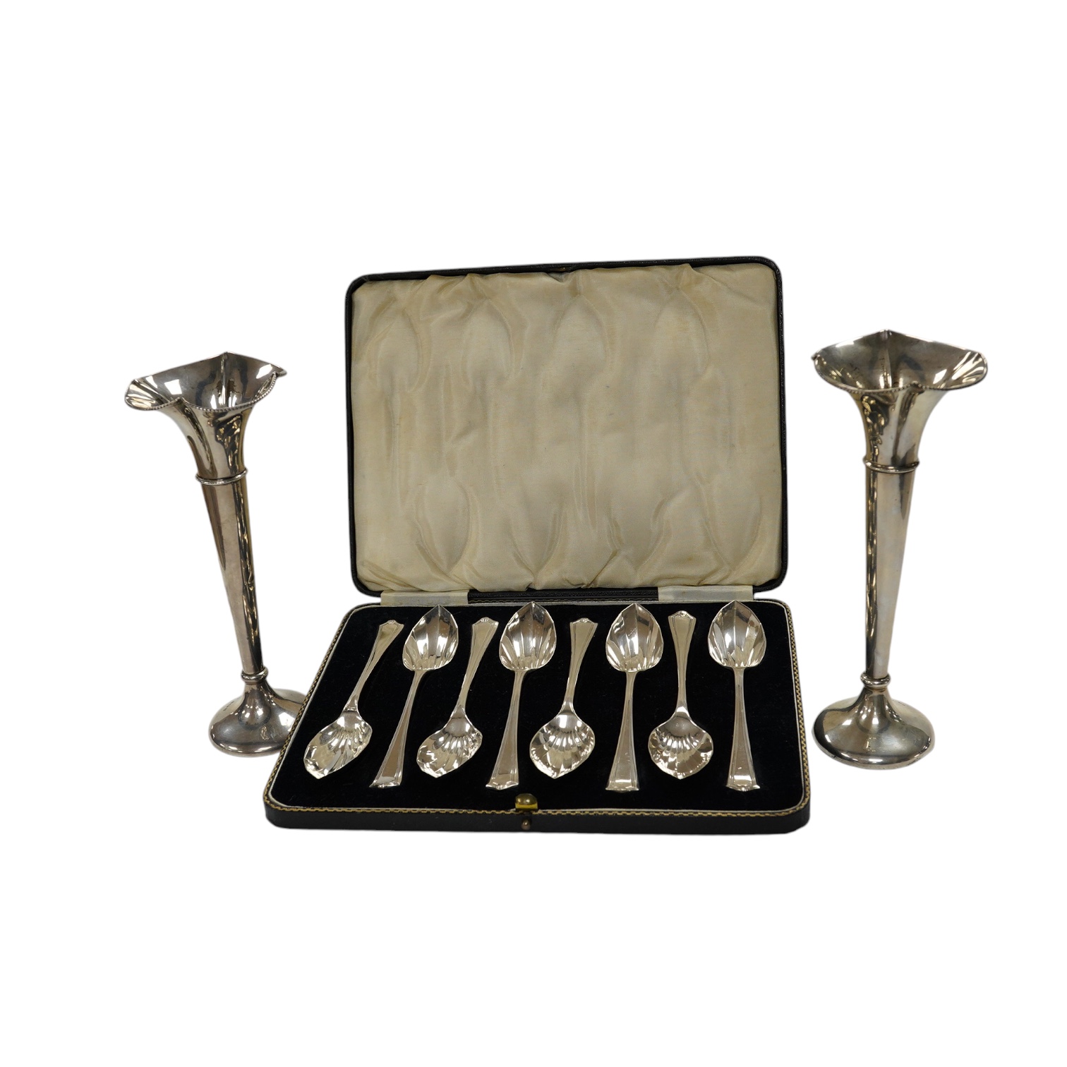 A cased set of eight George V silver grapefruit spoons, Sheffield, 1933 and a pair of silver spill vases, 17.5cm. Condition - poor to fair                                                                                  