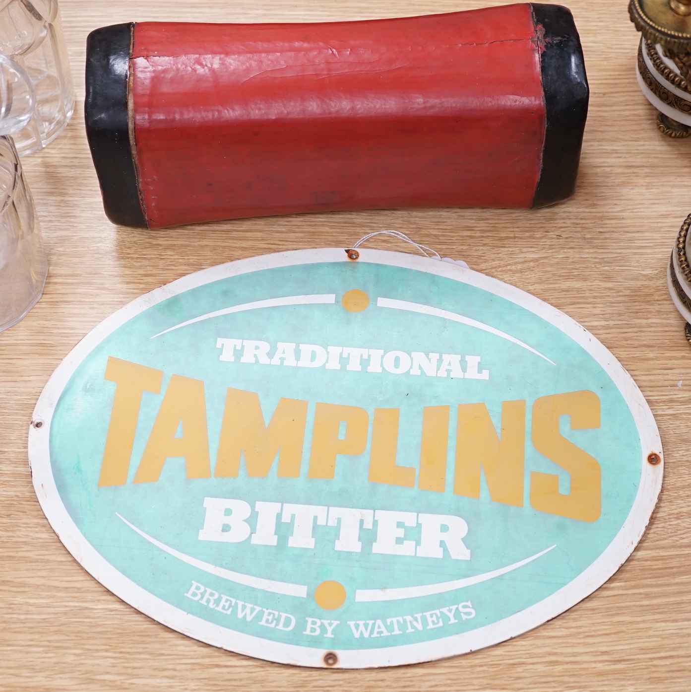 An oval Tamplins bitter advertising sign and a Japanese pillow, the largest 39cm wide                                                                                                                                       