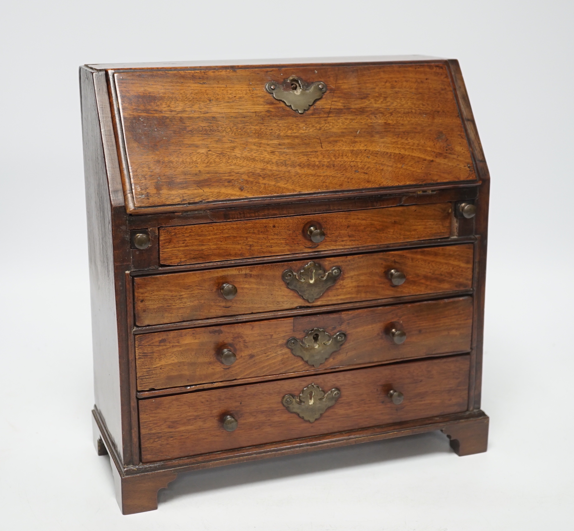 A George II miniature mahogany bureau with fitted interior and three drawers, 27cm high                                                                                                                                     