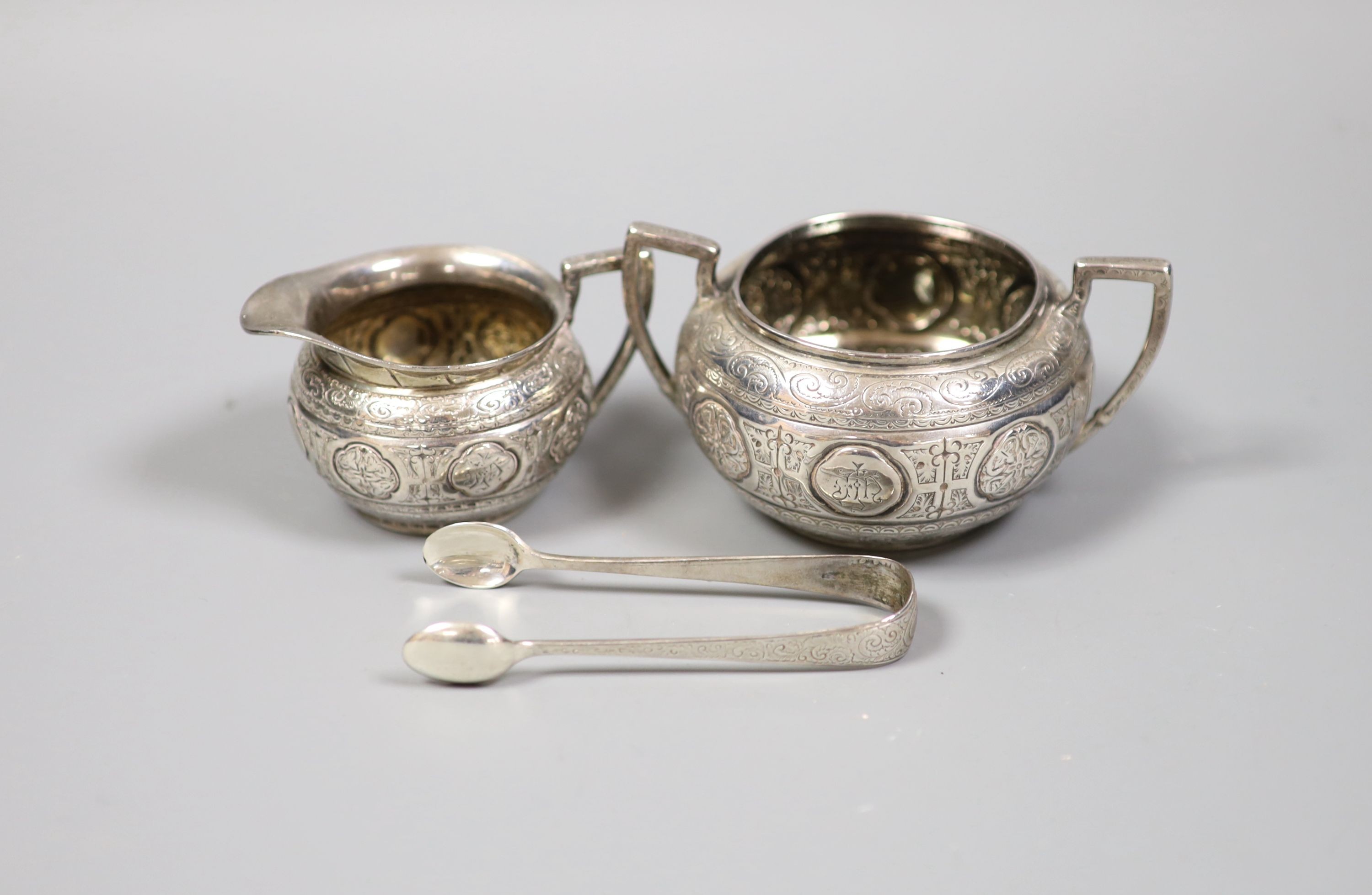 A Victorian engraved silver bachelors cream jug and sugar bowl and pair of matching sugar tongs, Fenton Brothers, Sheffield, 1876, 7.5oz.                                                                                   