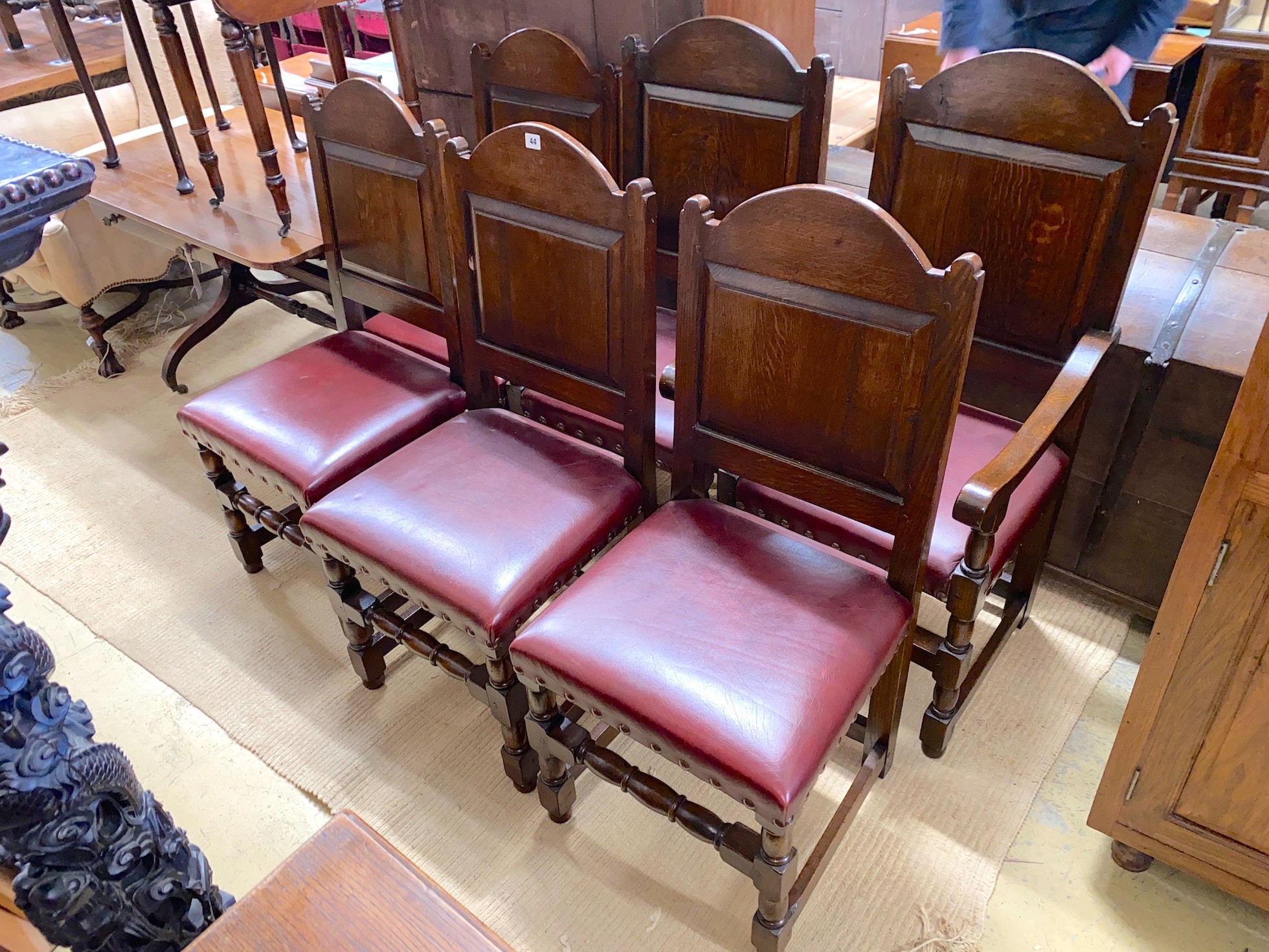 A set of six 18th century style panelled oak dining chairs, two with arms                                                                                                                                                   