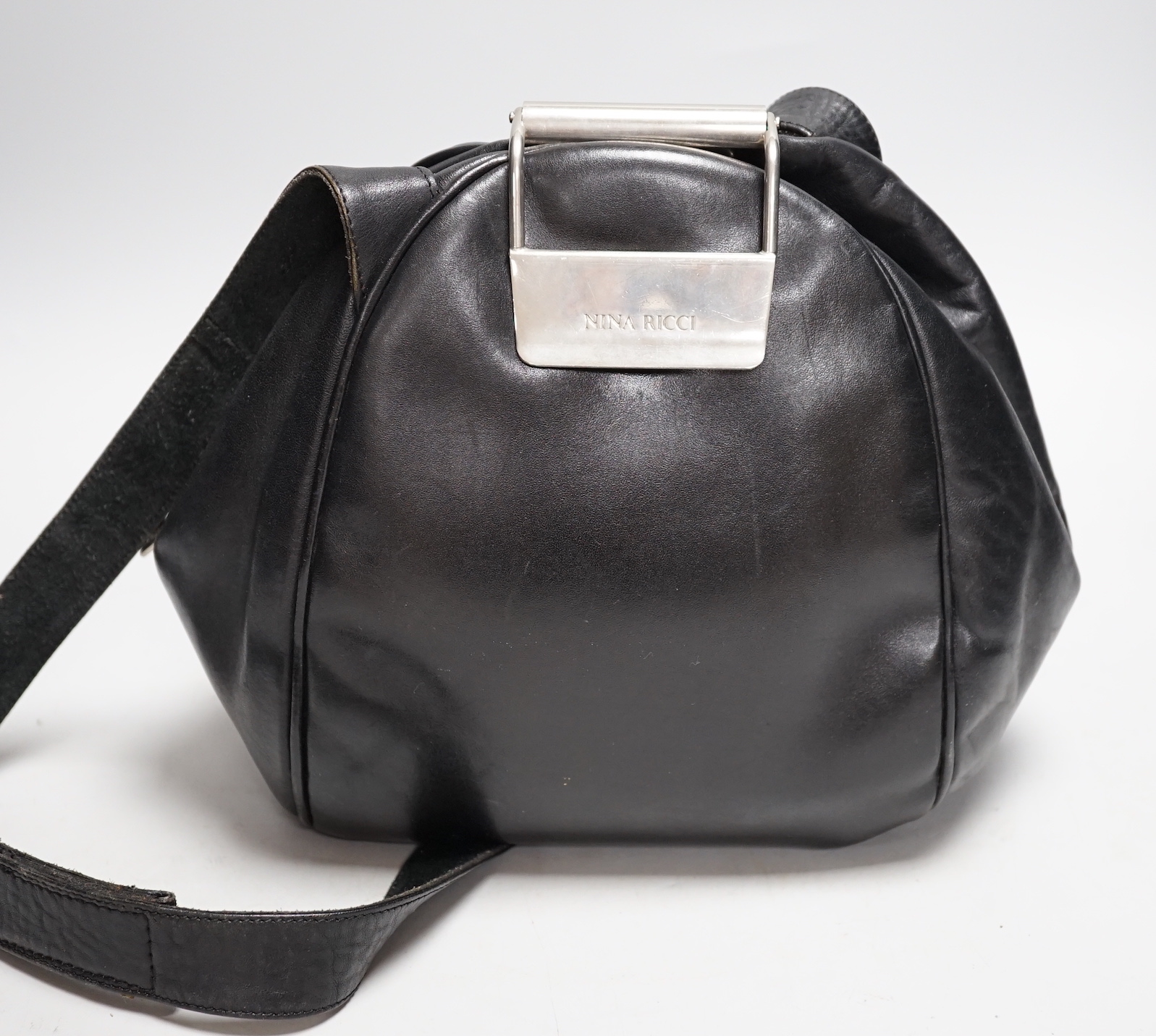 A Nina Ricci black leather shoulder bag with large metal clasp, engraved Nina Ricci, circa 1970's, approx. 23cm high                                                                                                        
