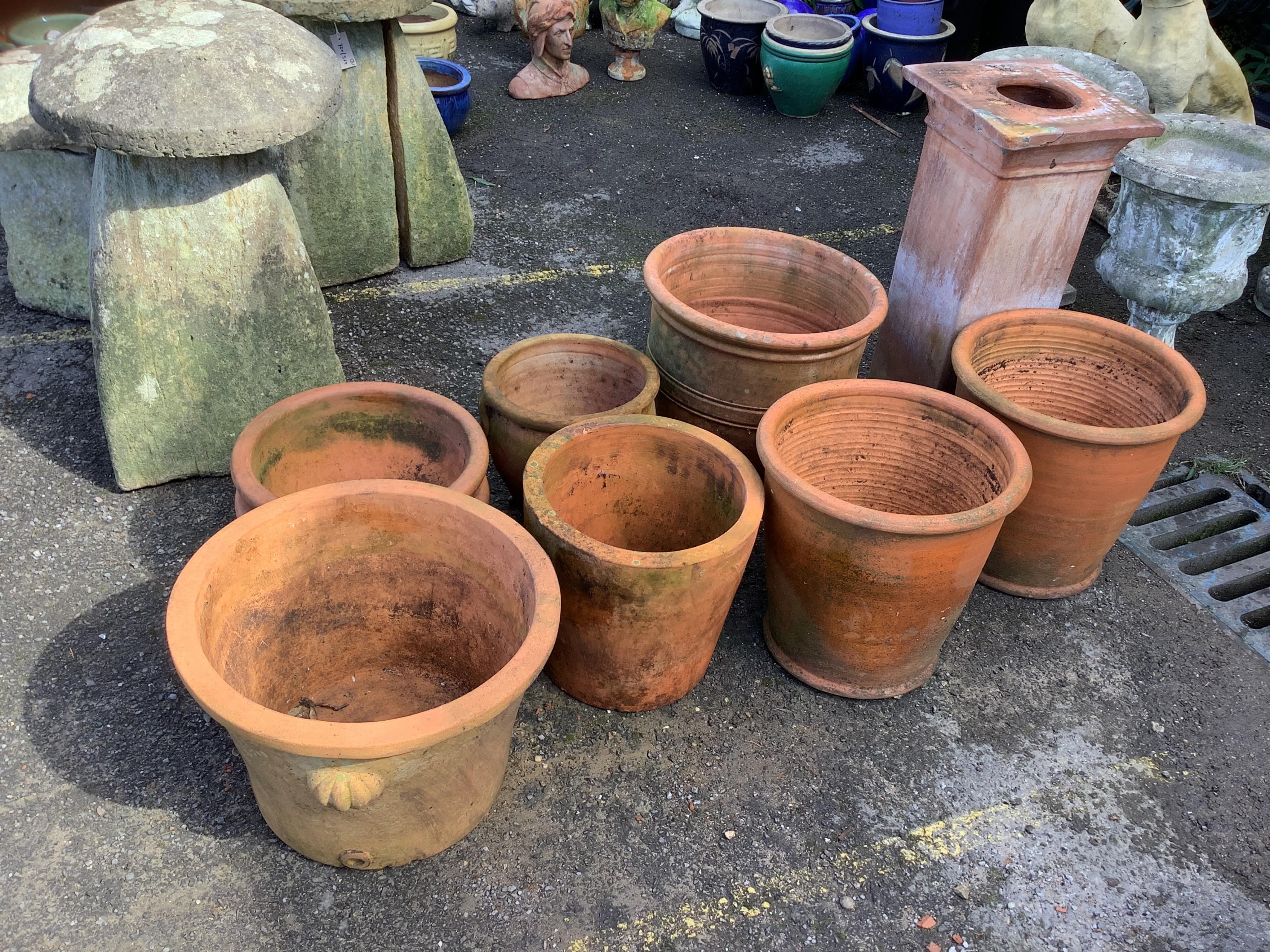 Twenty assorted terracotta planters, largest height 40cm, diameter 42cm, a terracotta pedestal, height 73cm, and a chimney cowl. Condition - all planters weathered, some with chips and losses, pedestal with top corner br