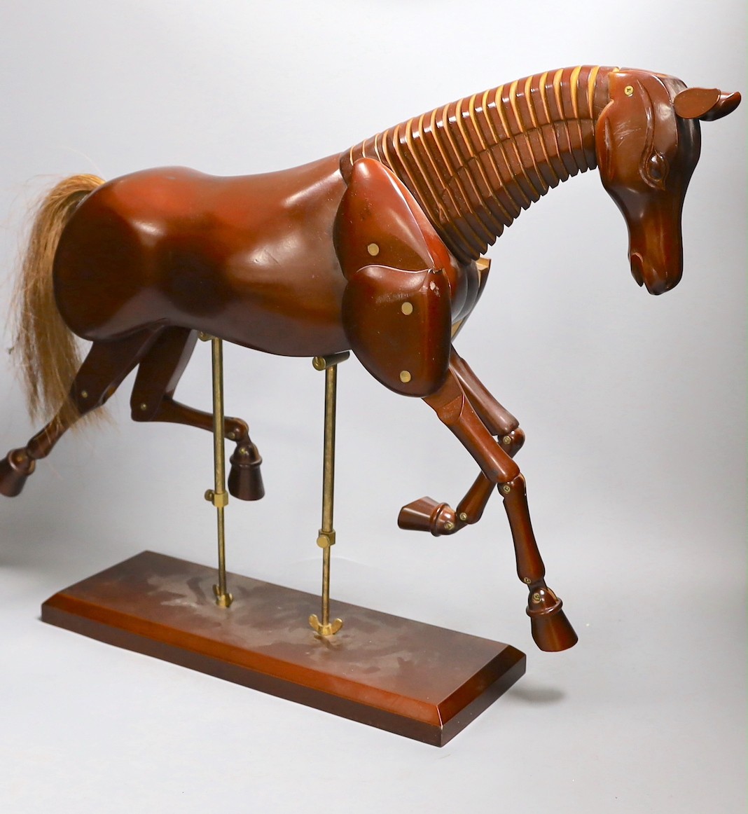 A modern artist's wooden articulated model of a horse, on stand, approx 51 cms wide x 46cms high                                                                                                                            