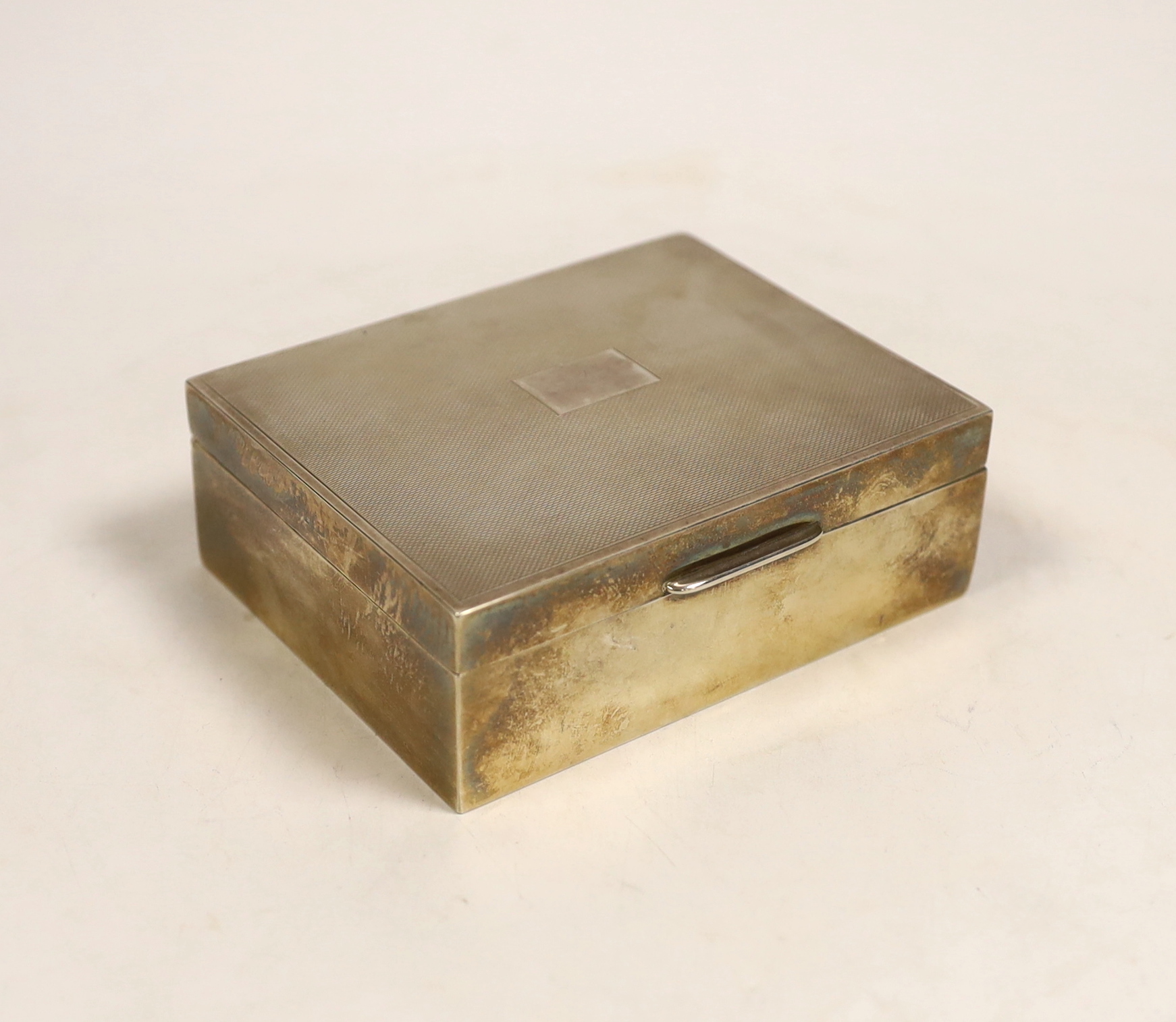 A 20th century part engine turned silver mounted cigarette box, 10.8cm, marks rubbed.                                                                                                                                       