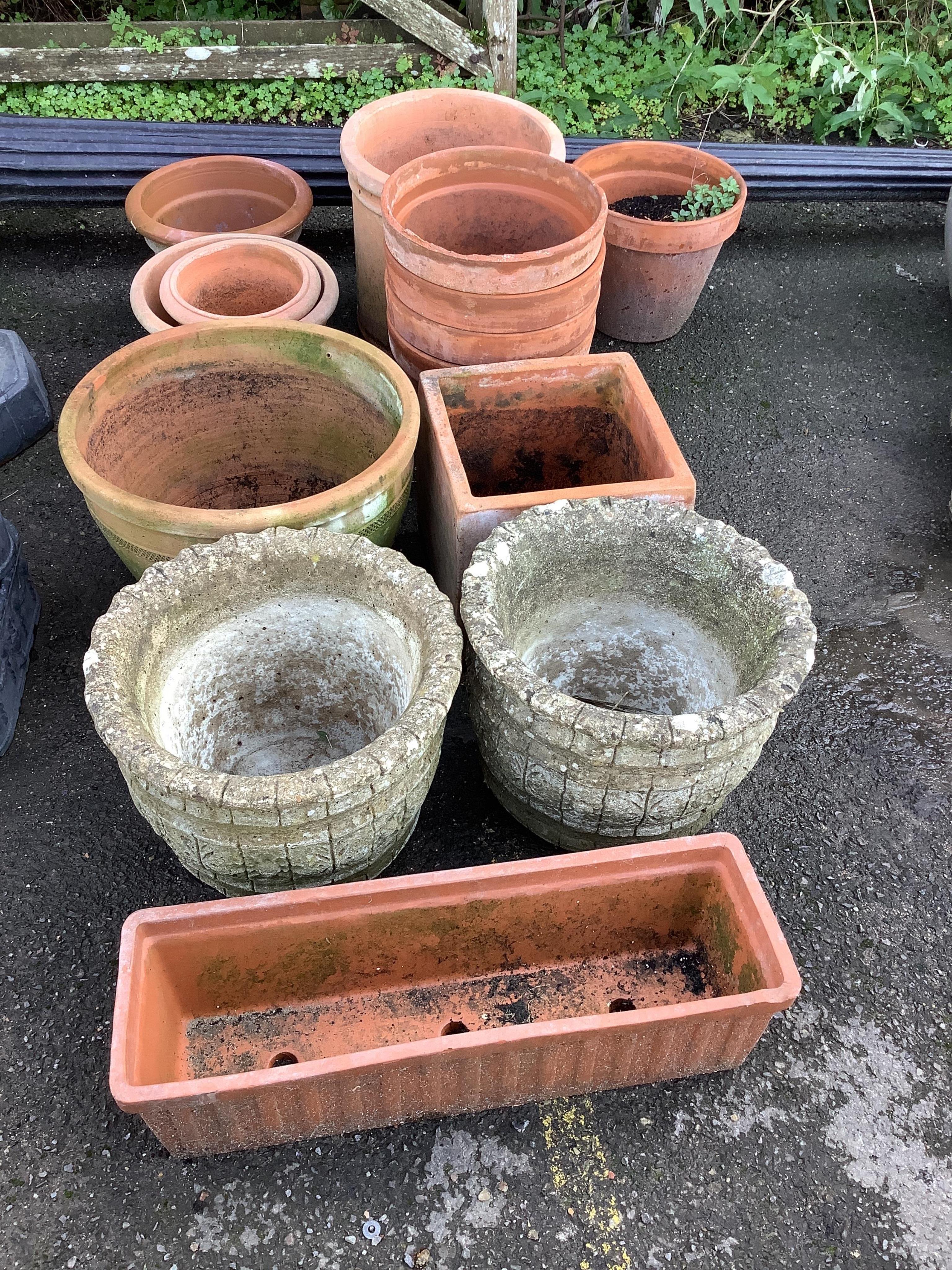 A group of twelve terracotta garden pots and planters and a pair of reconstituted stone garden planters, largest diameter 45cm, height 32cm. Condition - weathered                                                          