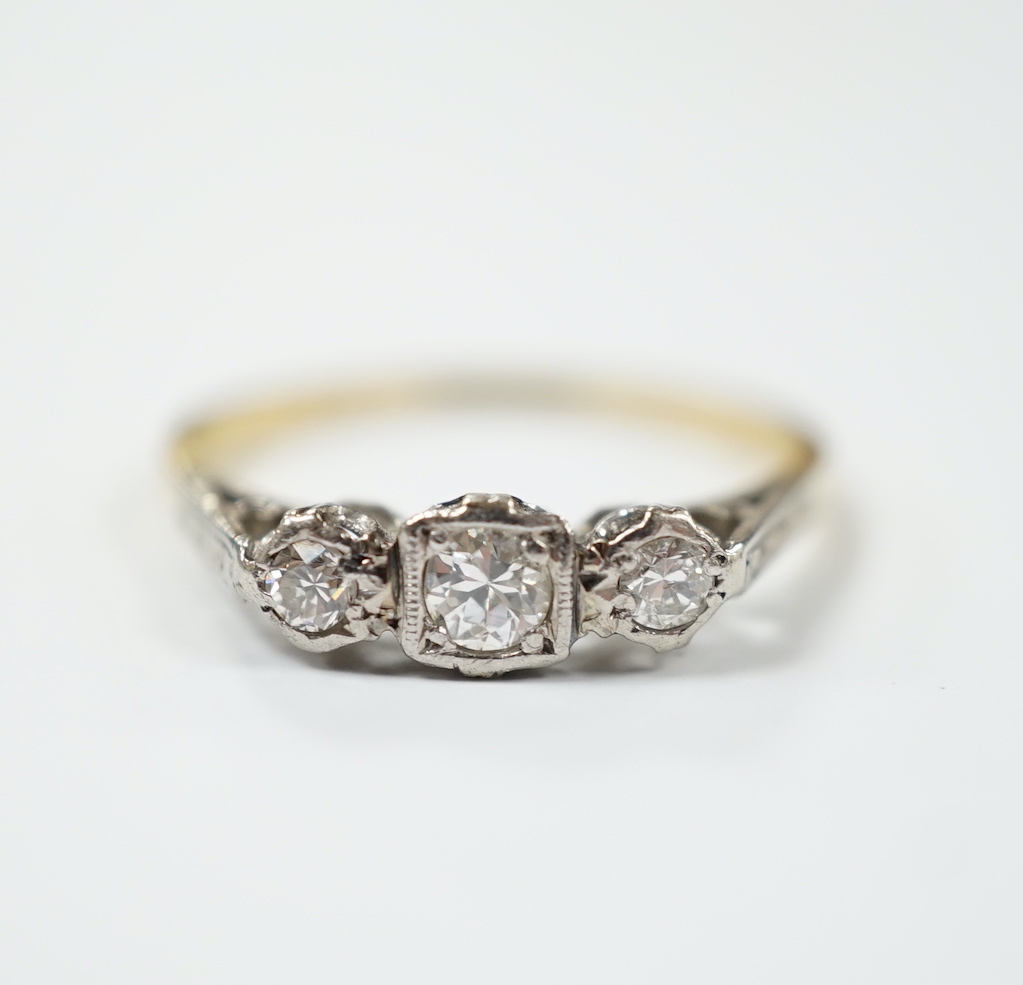 An 18ct, plat and three stone diamond set ring, size N/O, gross weight 2.1 grams.                                                                                                                                           