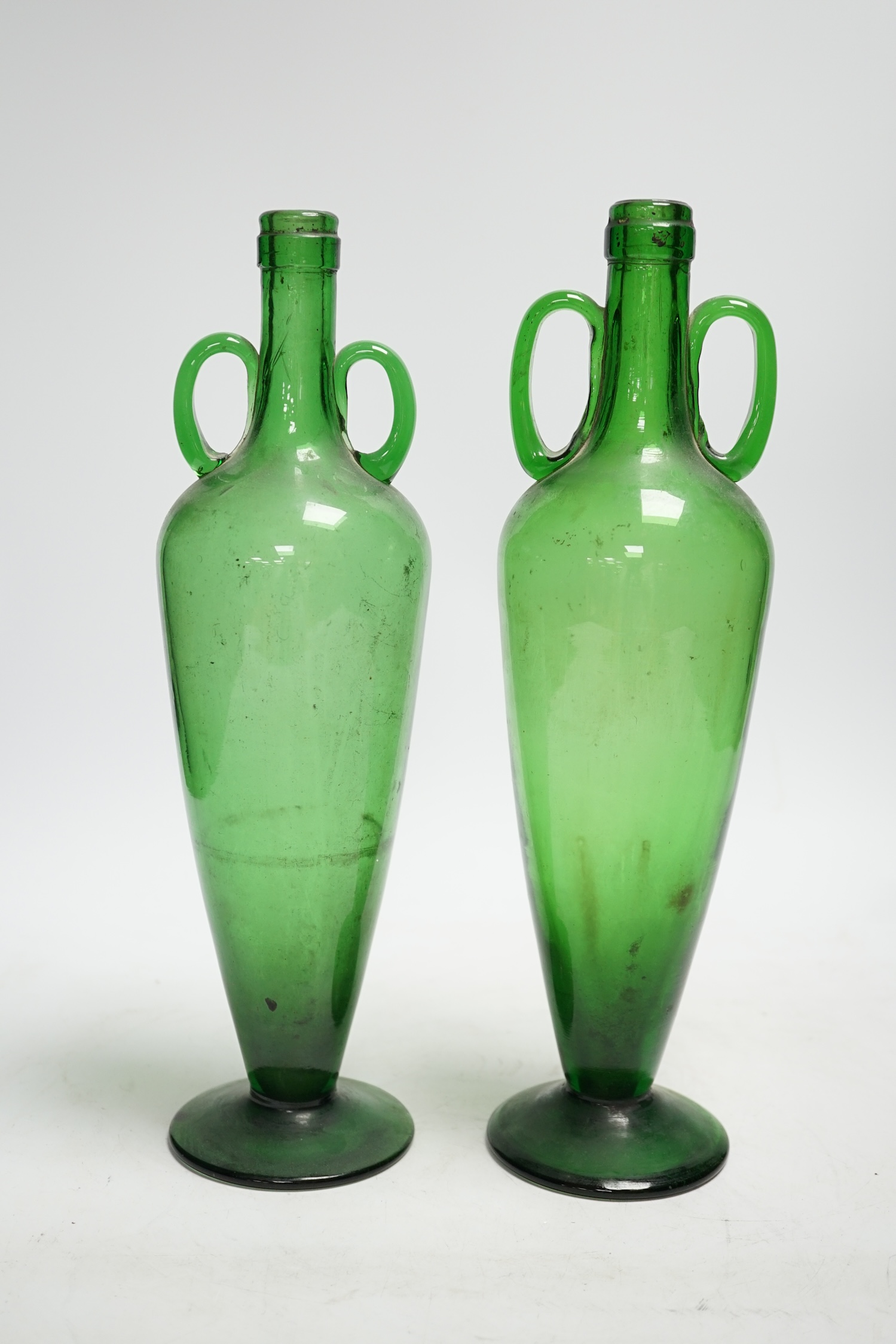 A pair of double handle green glass vases, 33cm                                                                                                                                                                             