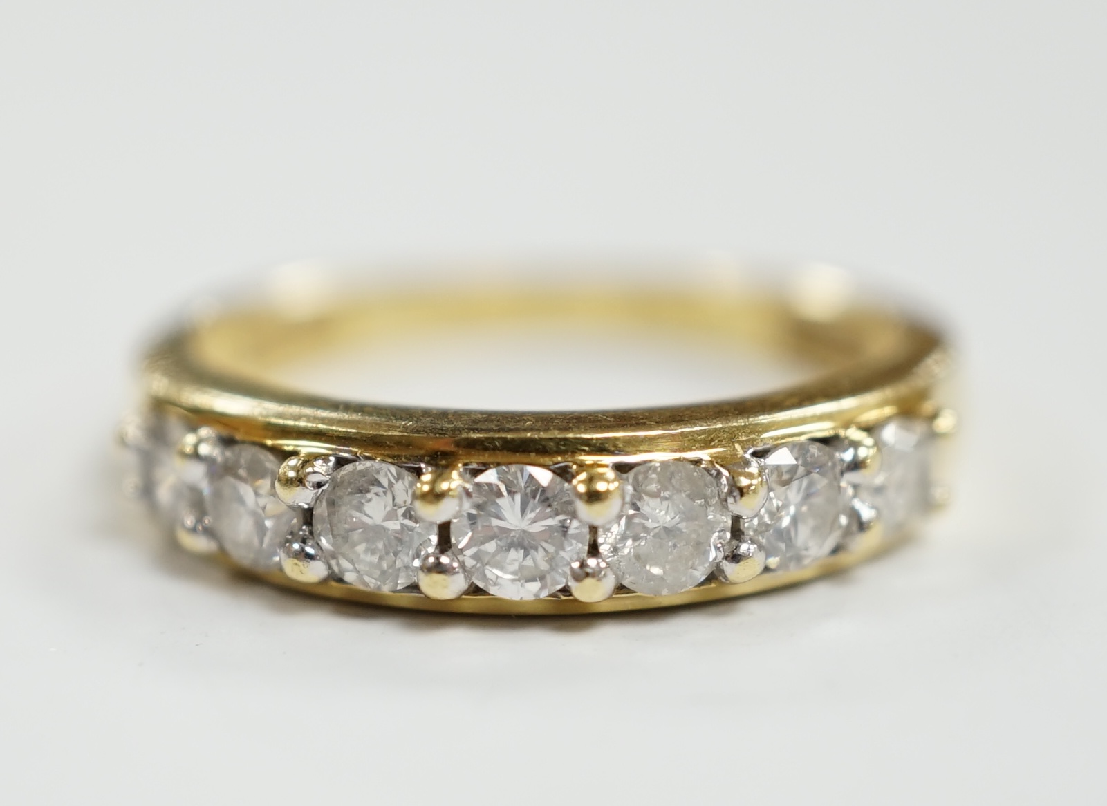 A modern 18ct gold and seven stone diamond set half hoop ring, size N, gross weight 4 grams.                                                                                                                                