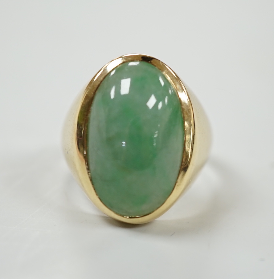 A modern 18ct gold and cabochon oval jade set ring, size P, gross weight 8.8 grams.                                                                                                                                         