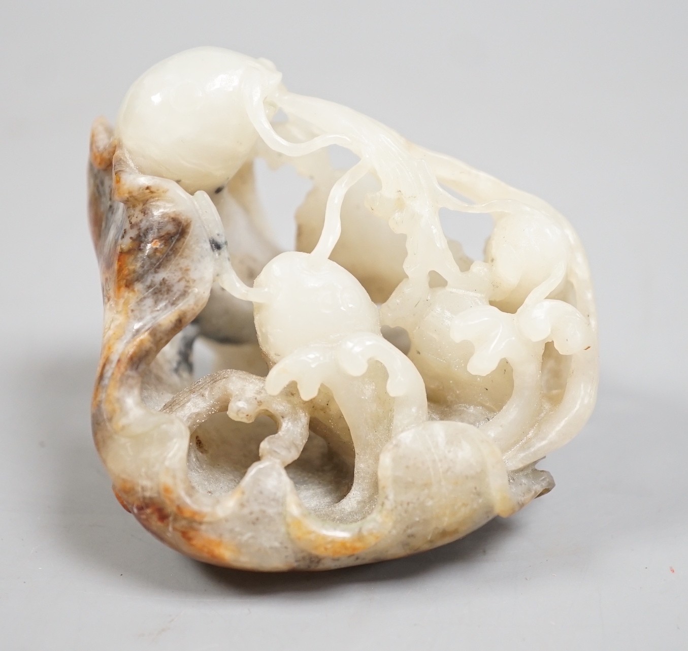 A Chinese pale grey and russet jade carving of carp amid lotus, 7.3 cm                                                                                                                                                      