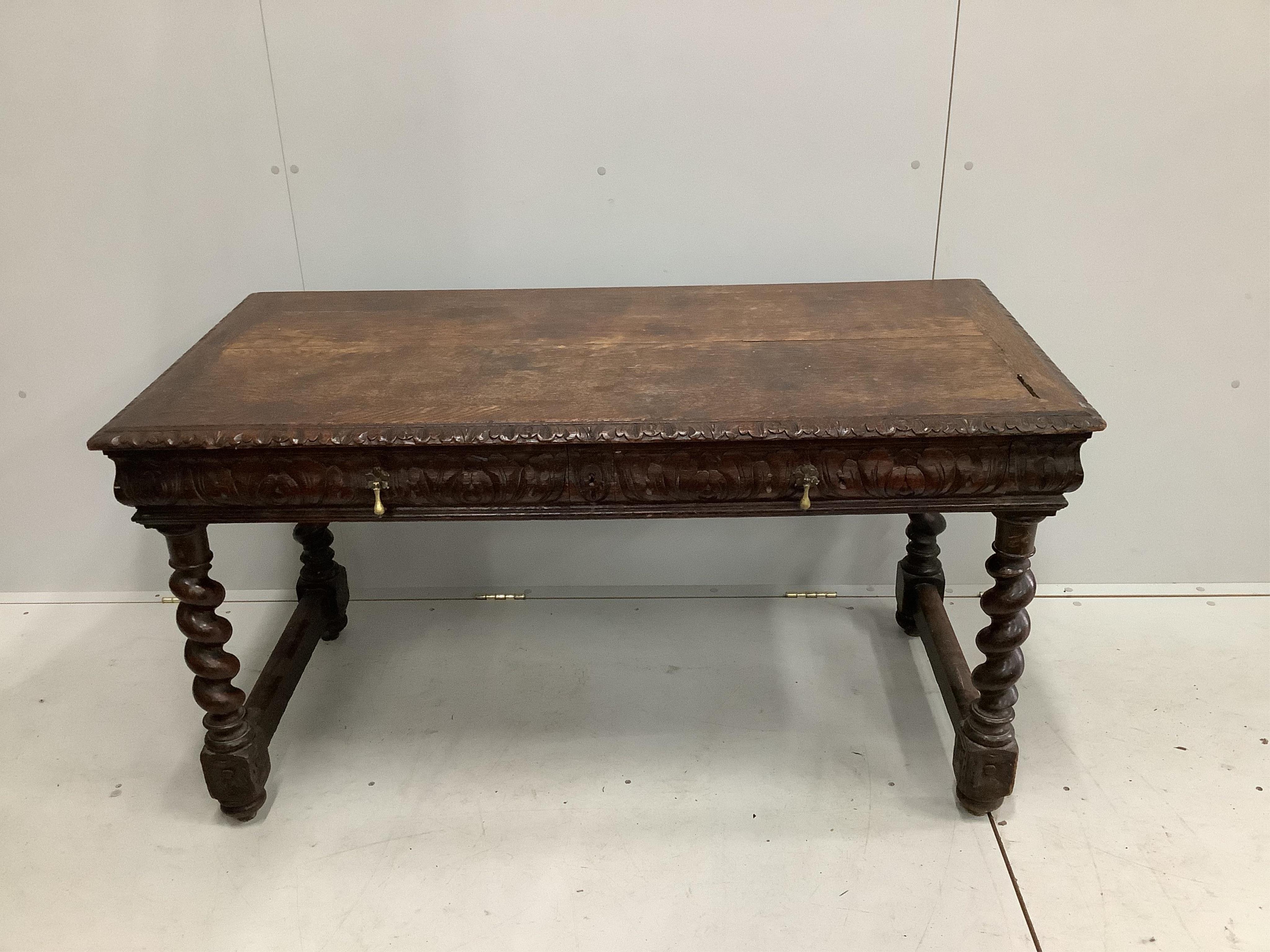 An early 20th century carved oak two drawer writing table, width 133cm, depth 67cm, height 72cm. Condition - fair                                                                                                           