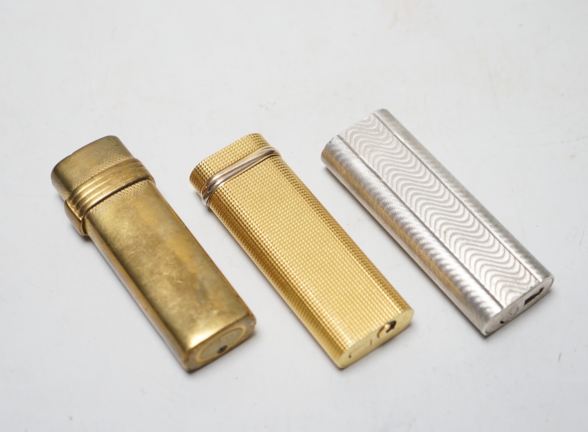 Two Cartier cigarette lighters and Christian Dior example                                                                                                                                                                   