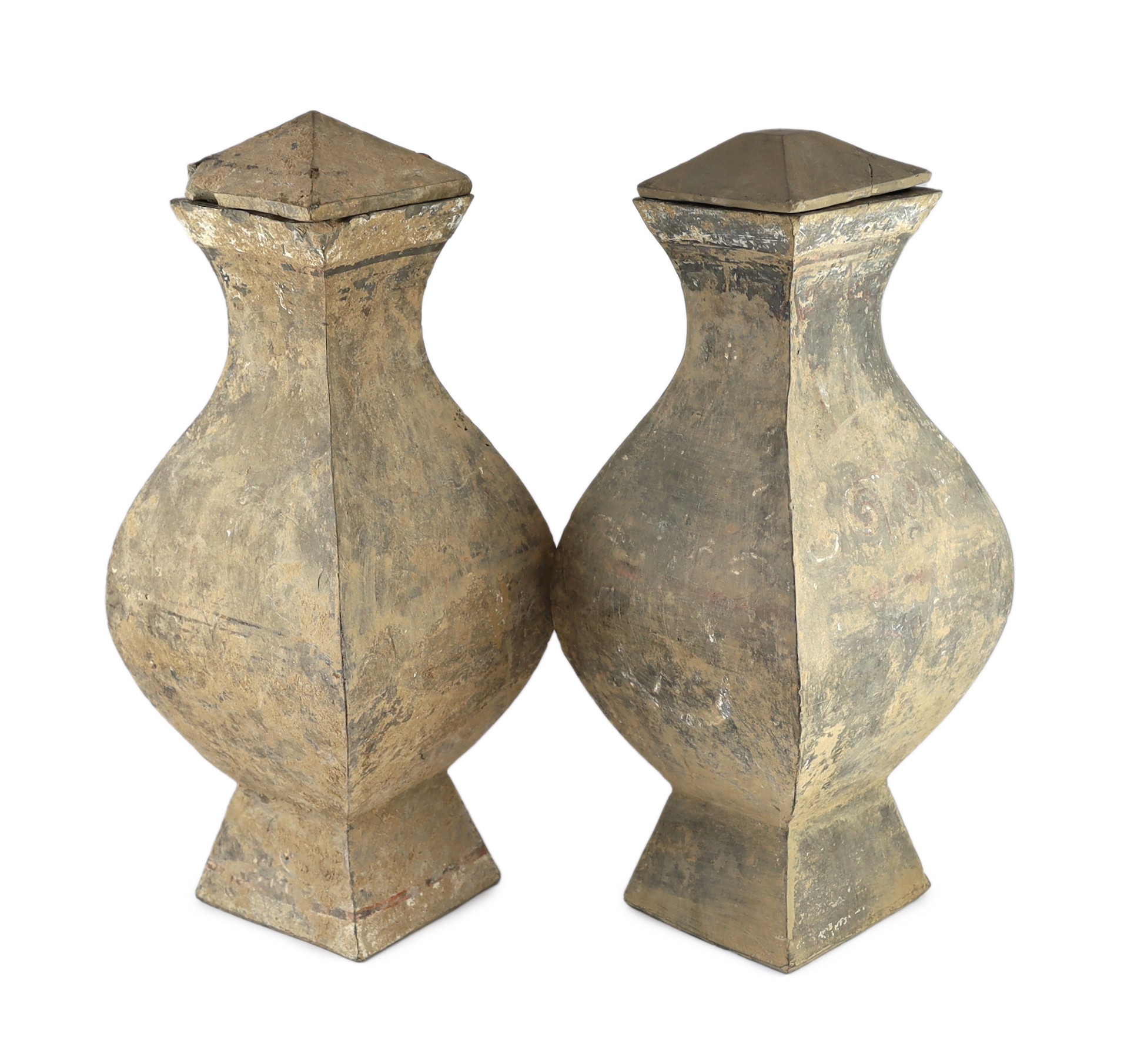 A pair of large Chinese painted terracotta wine jars and covers, fanghu, Han dynasty, 56cm high, one replacement cover and small losses                                                                                     