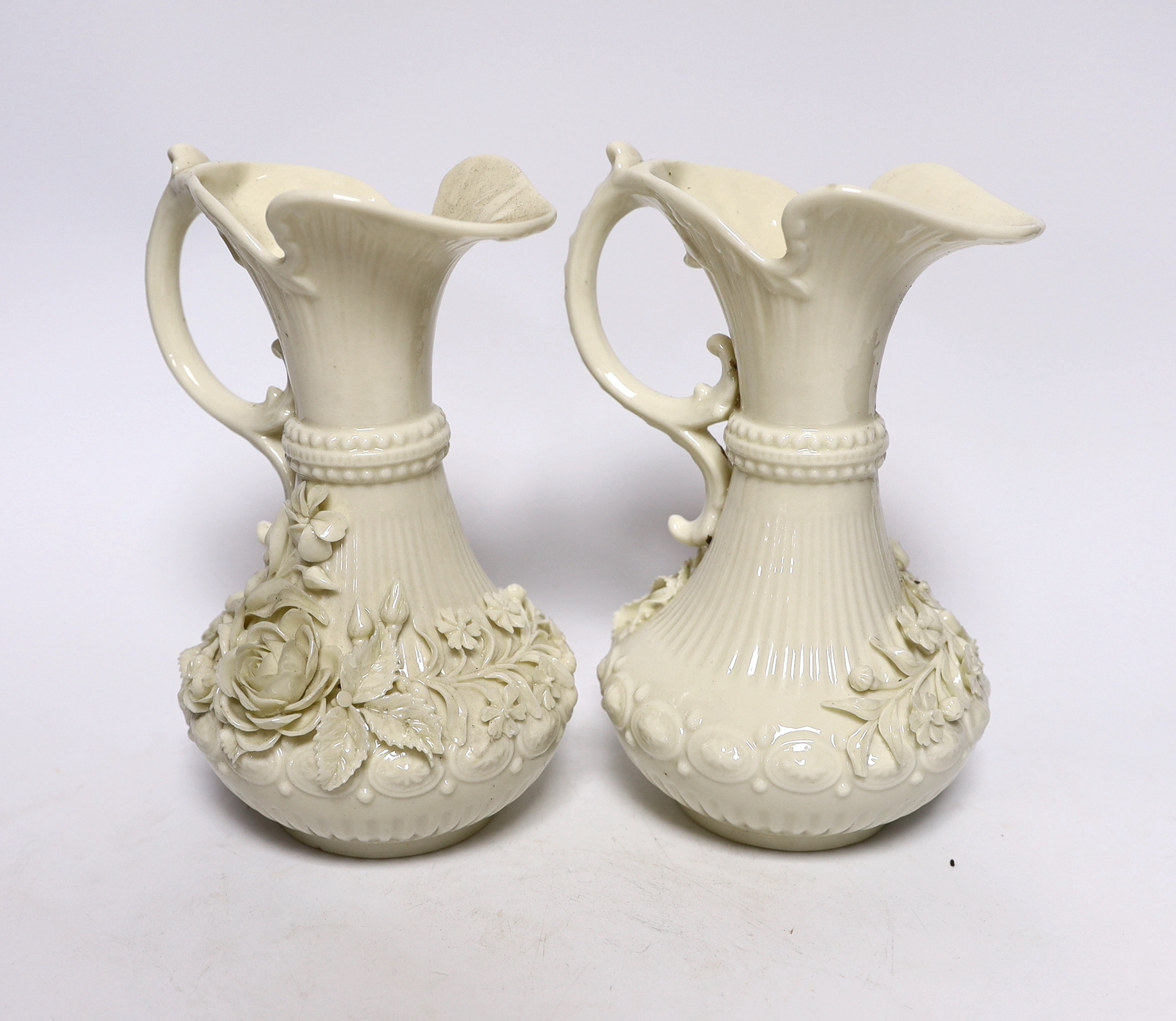 A pair of Belleek jugs with applied rose decoration, 19 cm high                                                                                                                                                             