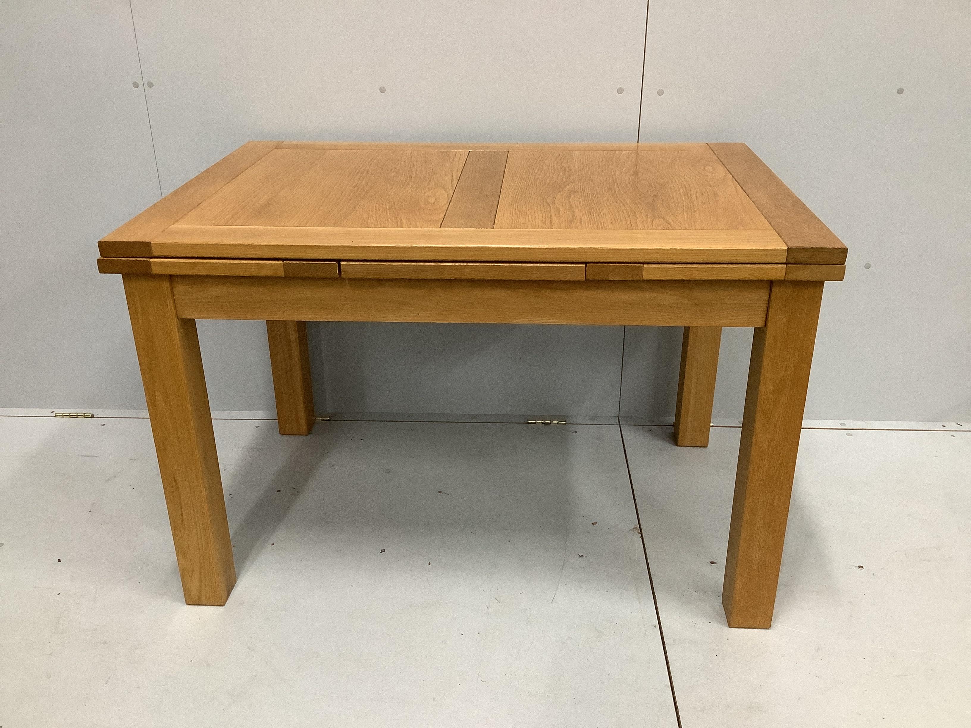 A contemporary oak draw leaf extending dining table, width 200cm extended, depth 80cm, height 78cm together with a set of four matching dining chairs                                                                       