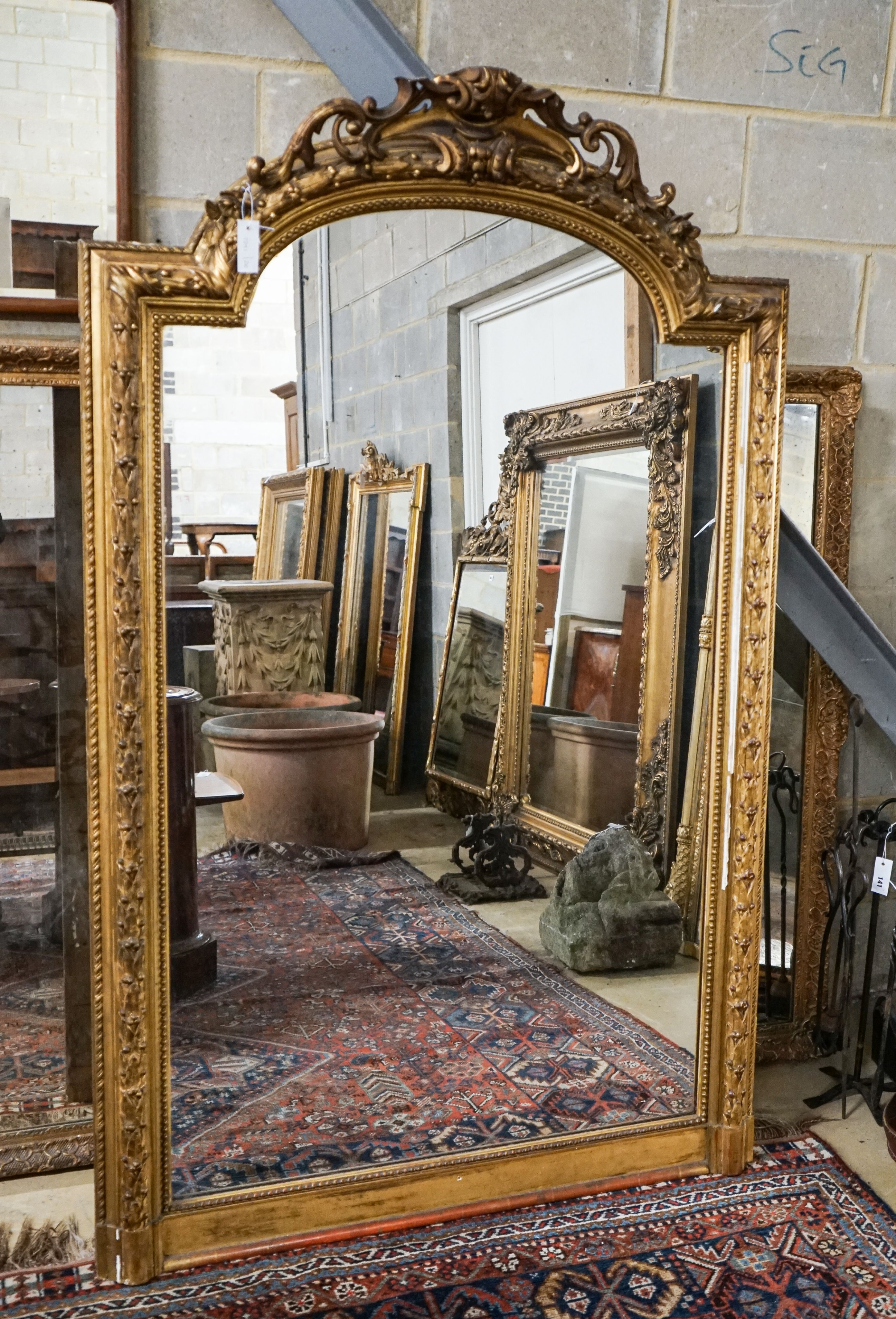 A Victorian giltwood and gesso overmantel mirror with arched scroll pediment, width 112cm, height 180cm                                                                                                                     