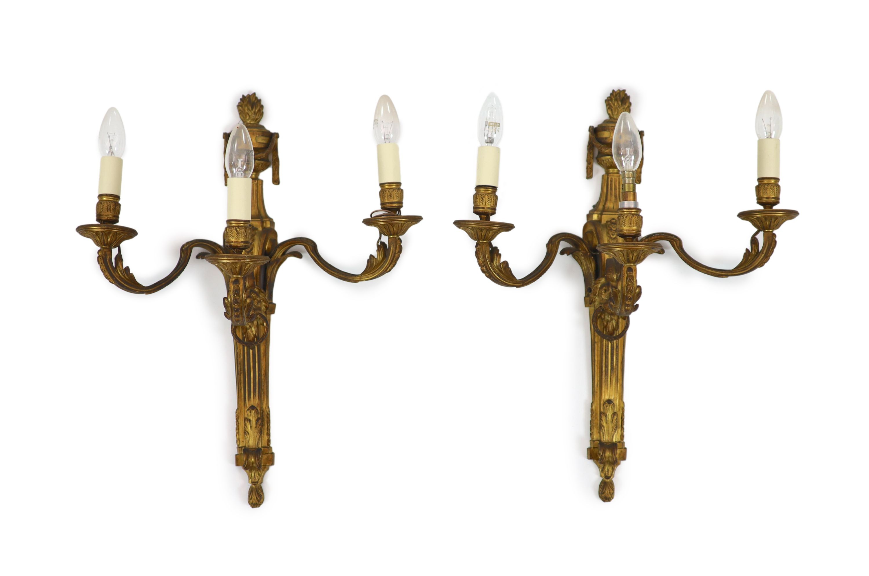 A pair of Louis XVI style ormolu three branch wall lights H 55cm. W 45cm.                                                                                                                                                   
