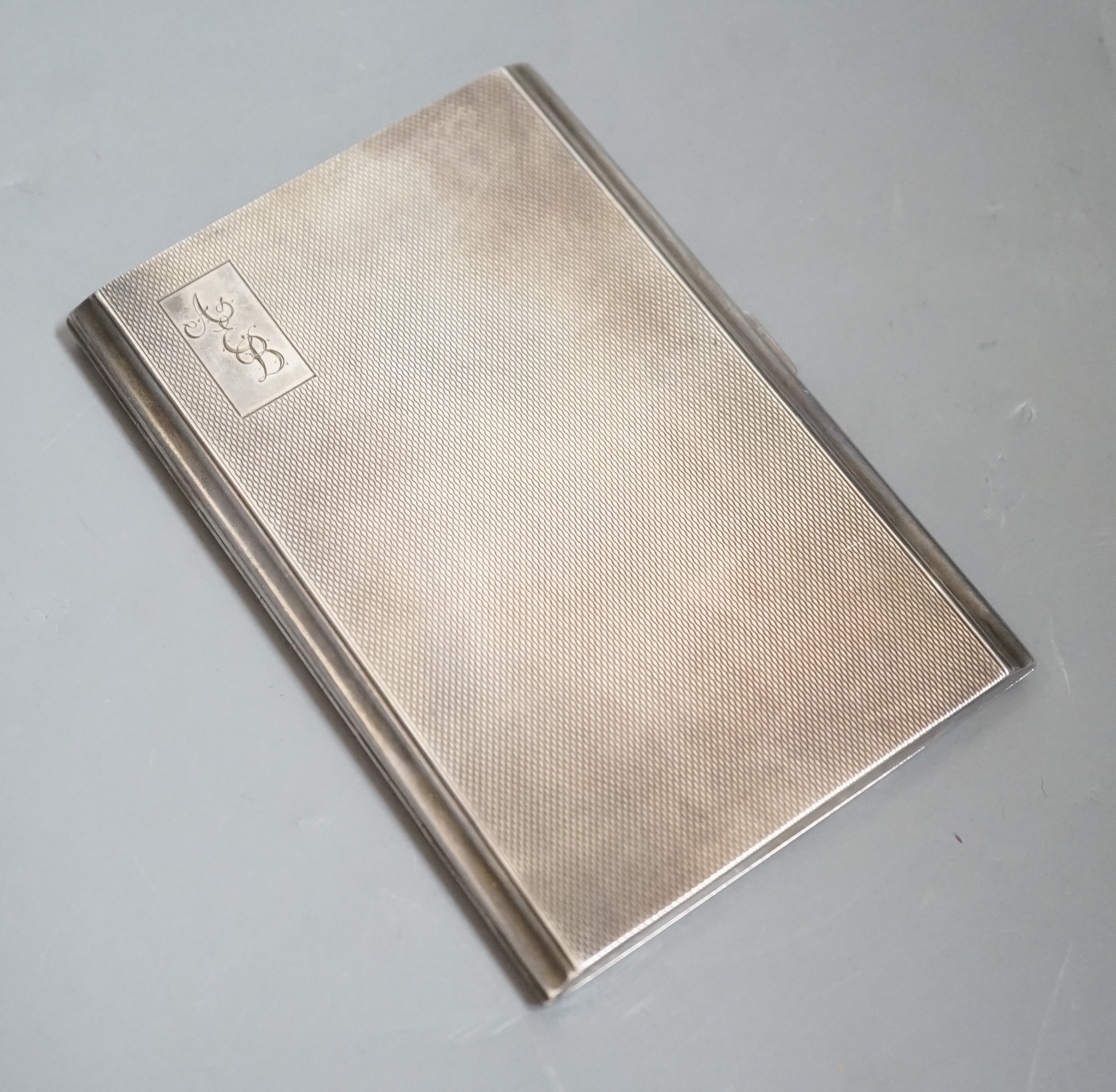 A George V engine turned silver rectangular cigarette case, 12.2cm, with engraved initials.                                                                                                                                 