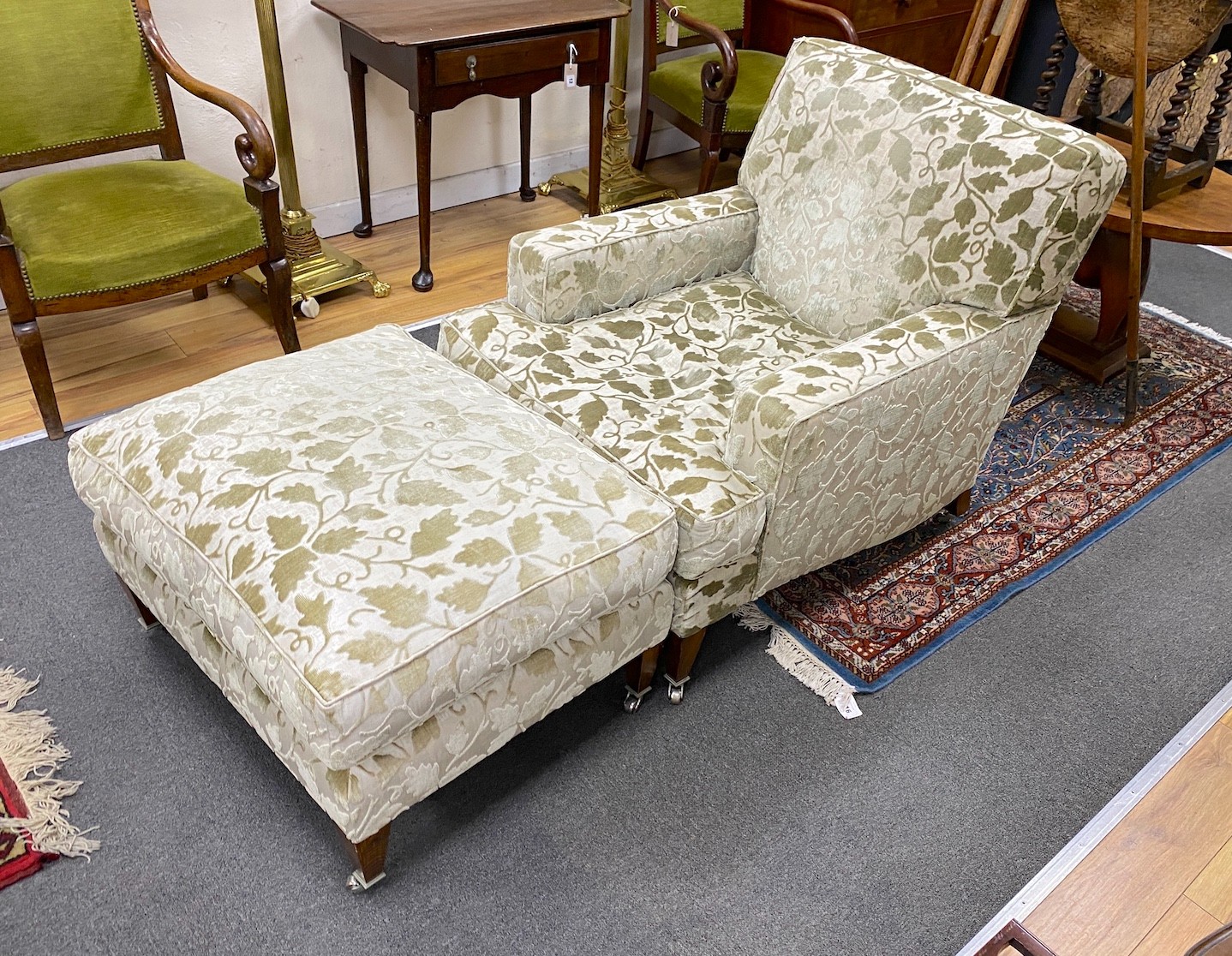 A contemporary Howard style armchair, width 79cm, depth 104cm, height 82cm and a footstool                                                                                                                                  