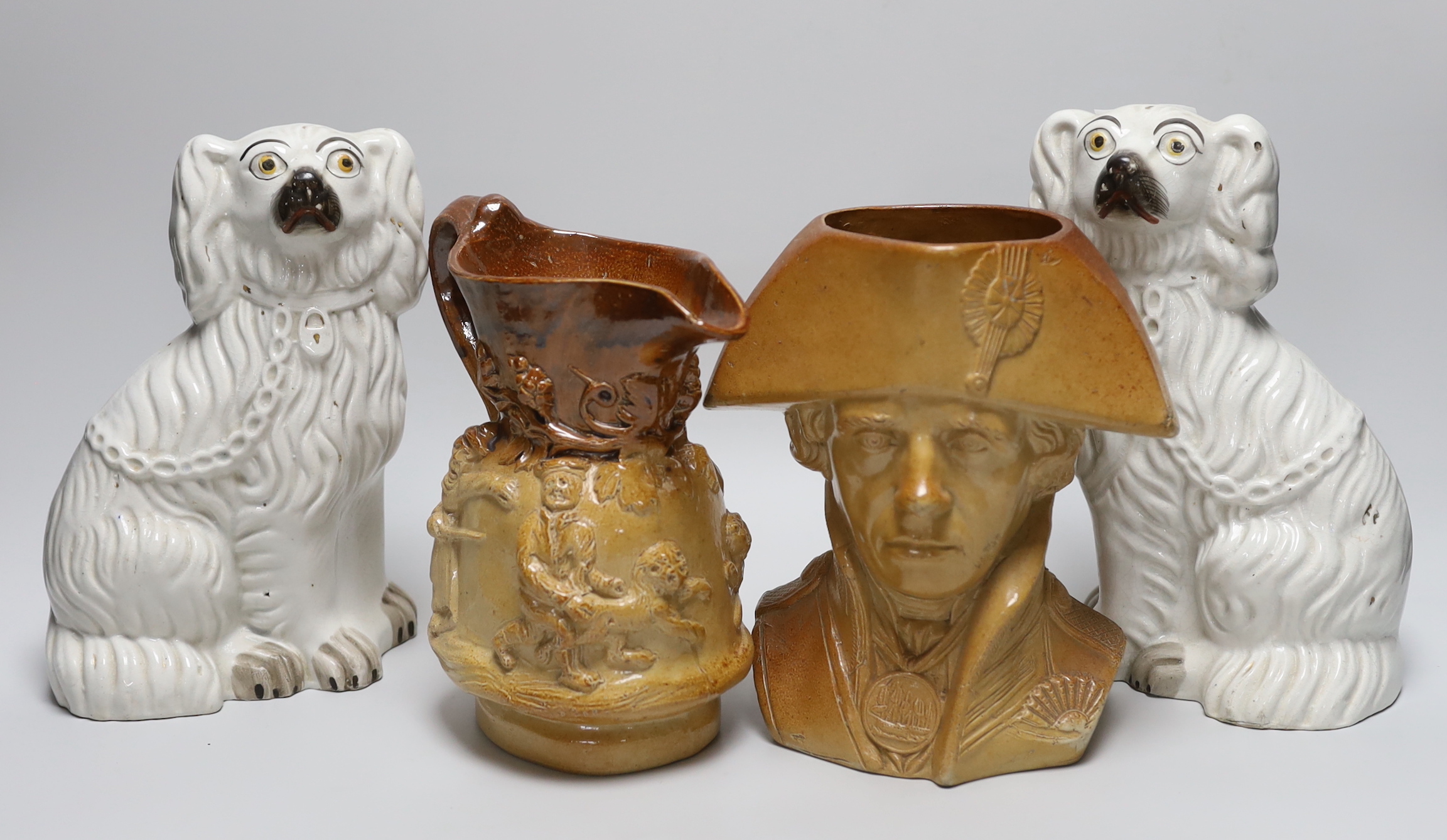 A Doulton and Watts glazed stoneware bust of Lord Nelson, a pair of white glazed Staffordshire pottery dogs and a Victorian earthenware jug (4)                                                                             