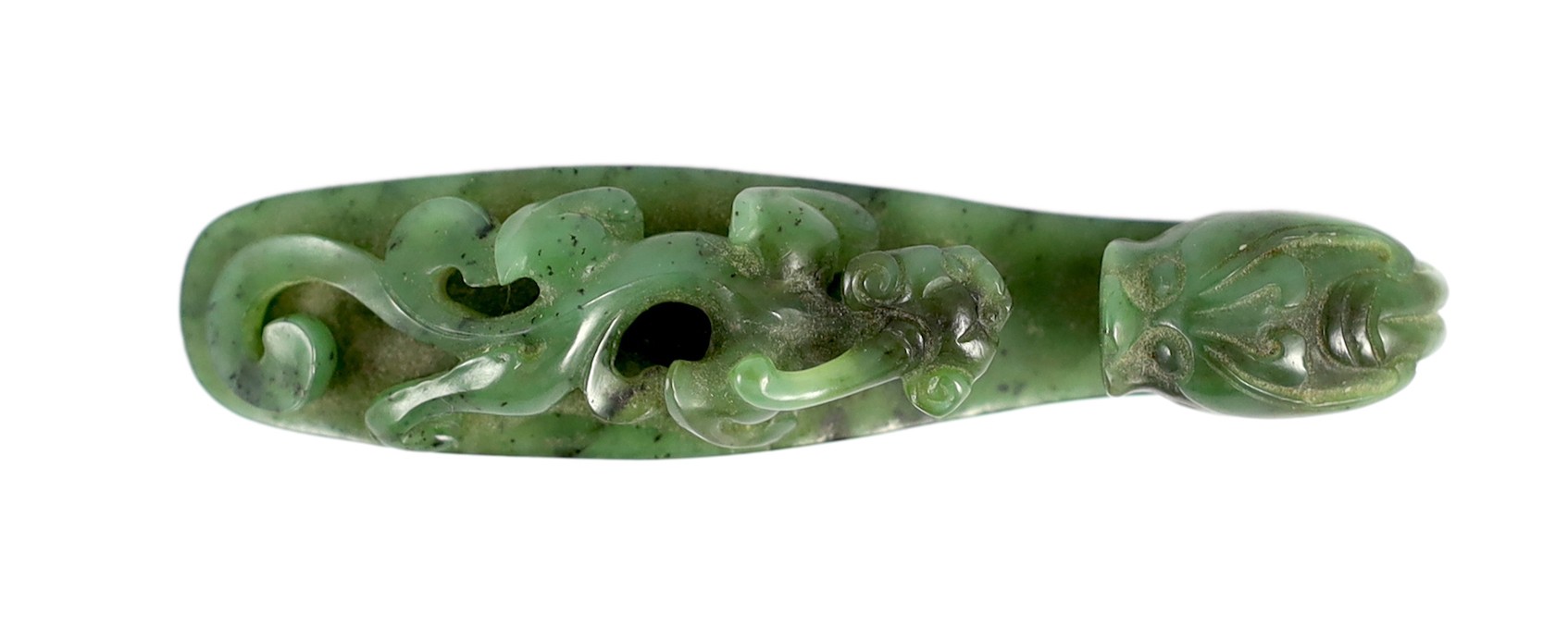 A Chinese bright spinach green jade ‘dragon’ belt hook, 18th/19th century, 9.5cm long                                                                                                                                       
