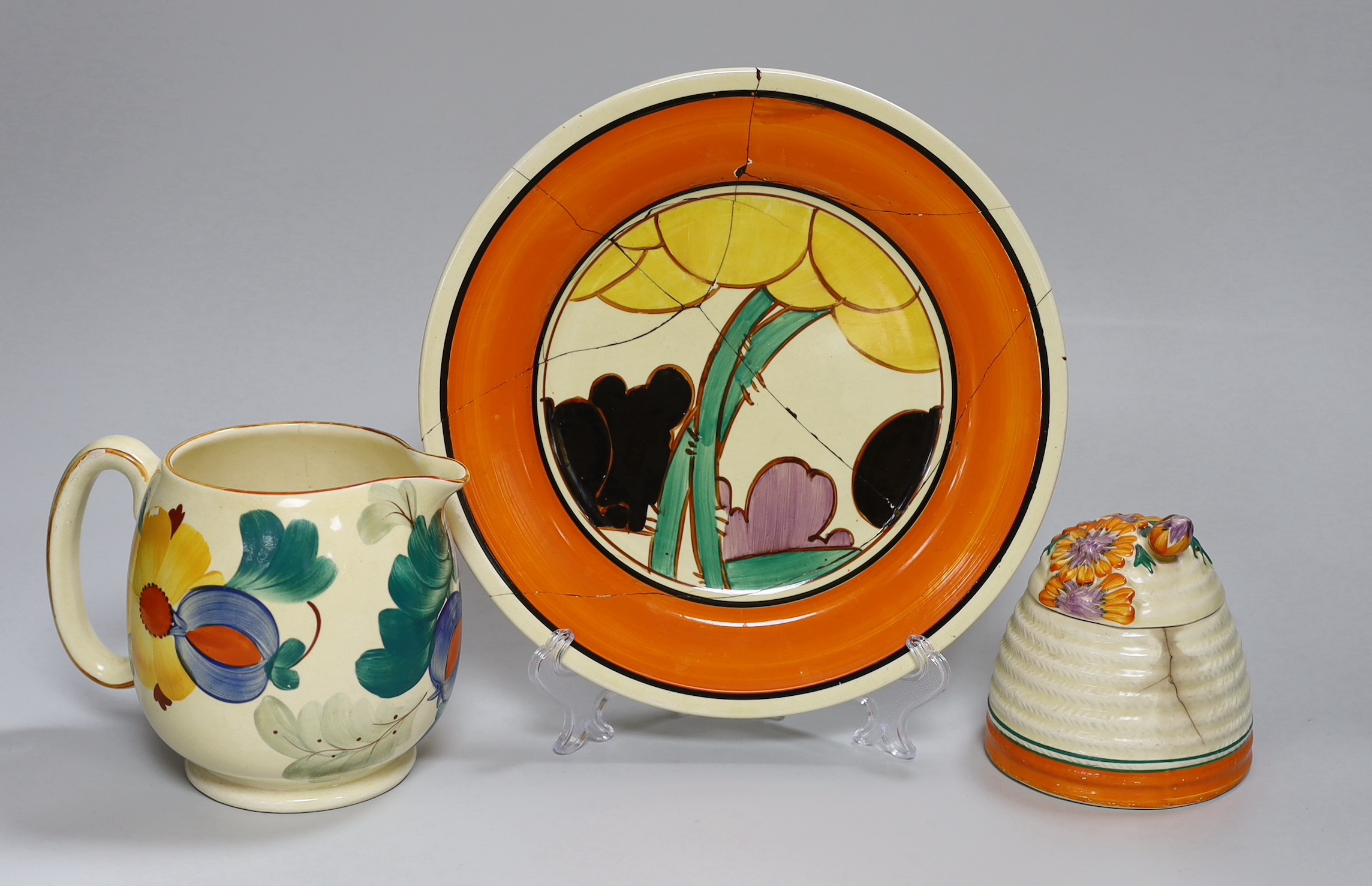 An early Clarice Cliff Fantasque plate, a Clarice Cliff honey pot and a Gray's jug, a.f.                                                                                                                                    