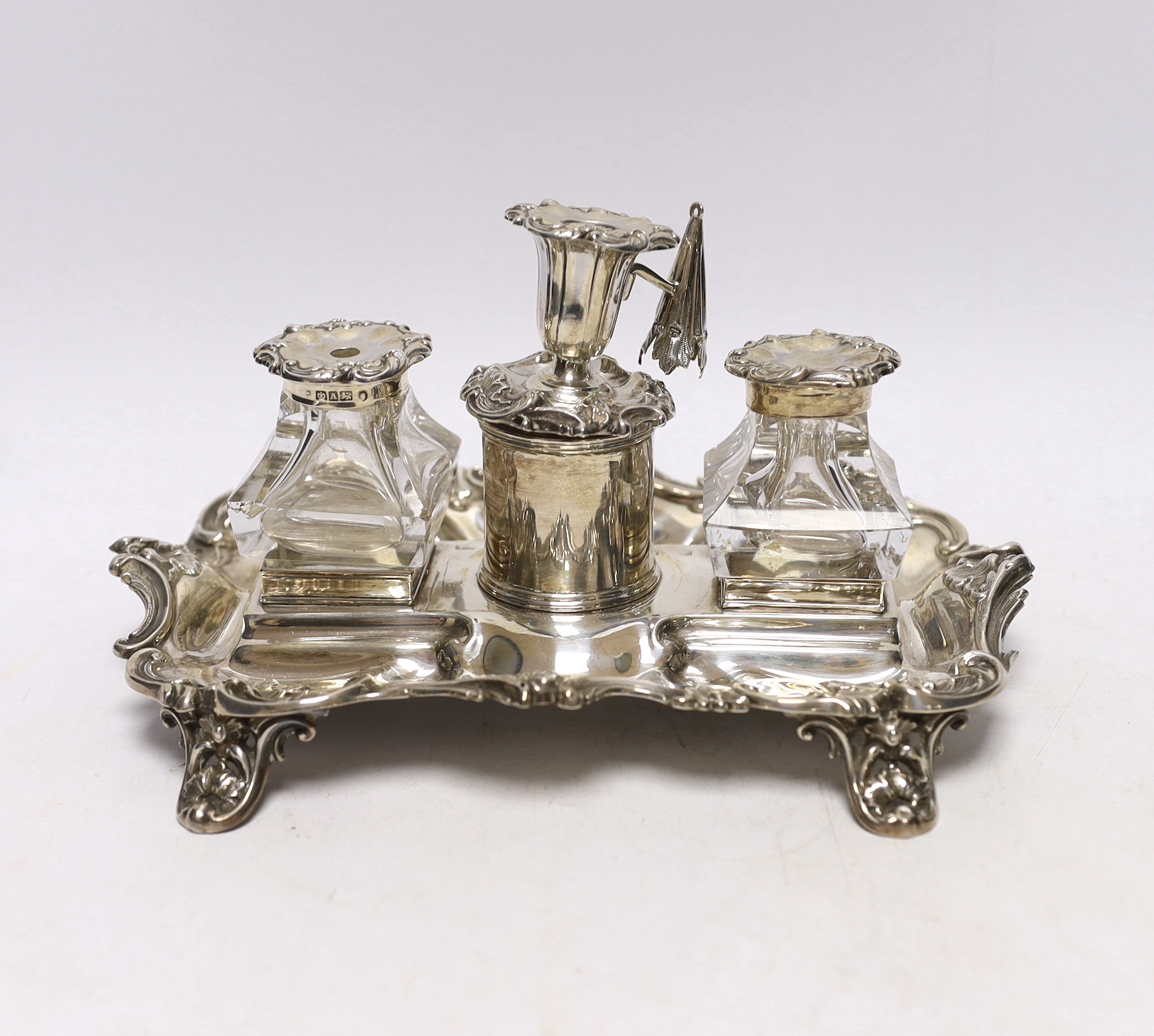 An early Victorian ornate silver inkstand, with two mounted glass wells and central taperstick, Henry Wilkinson & Co, Sheffield, 1844, 21cm                                                                                 