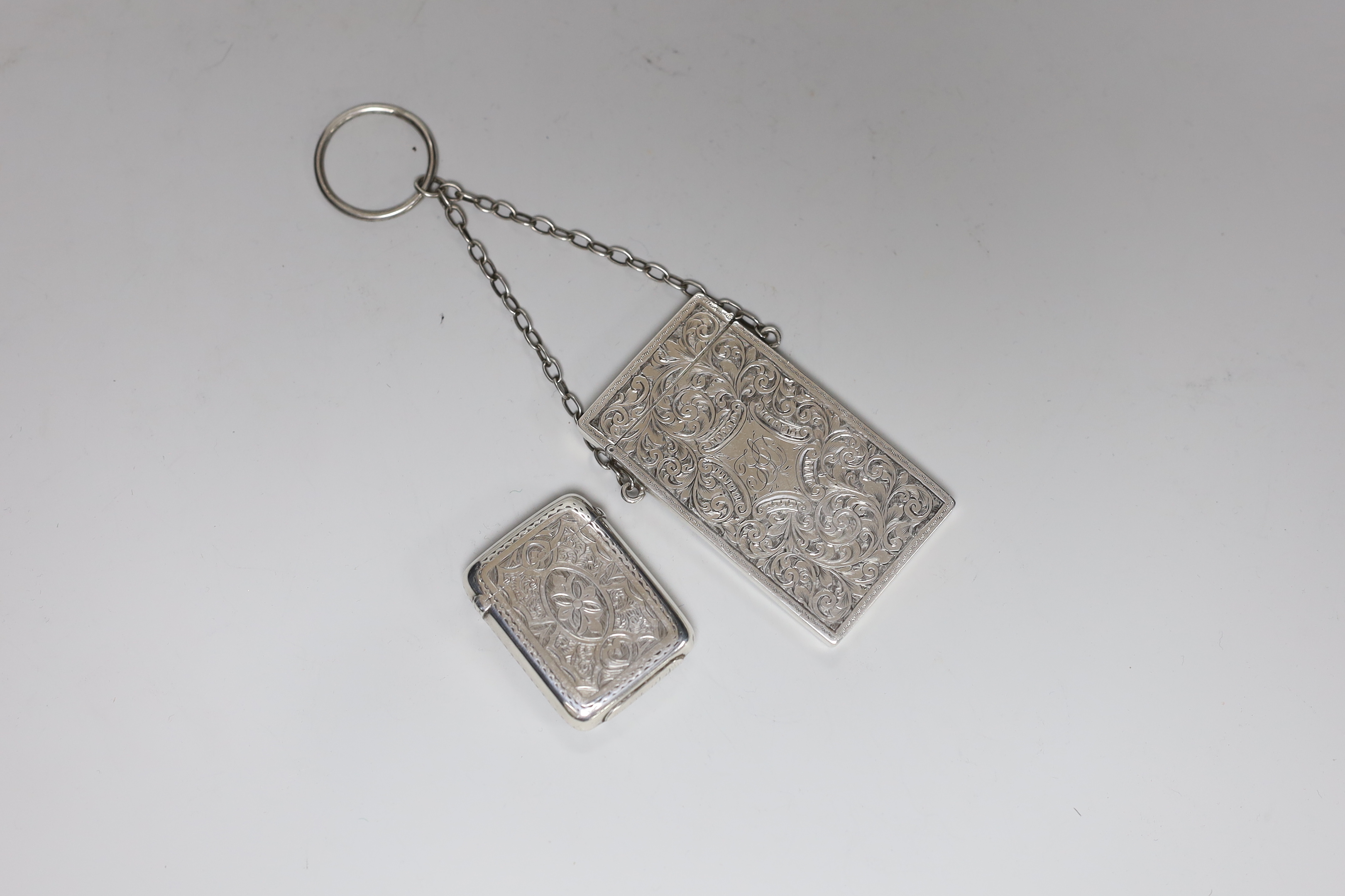 A late Victorian chased silver card case, S. Blanckensee & Son Ltd, Birmingham, 1886, 76mm and a Victorian silver vesta case.                                                                                               