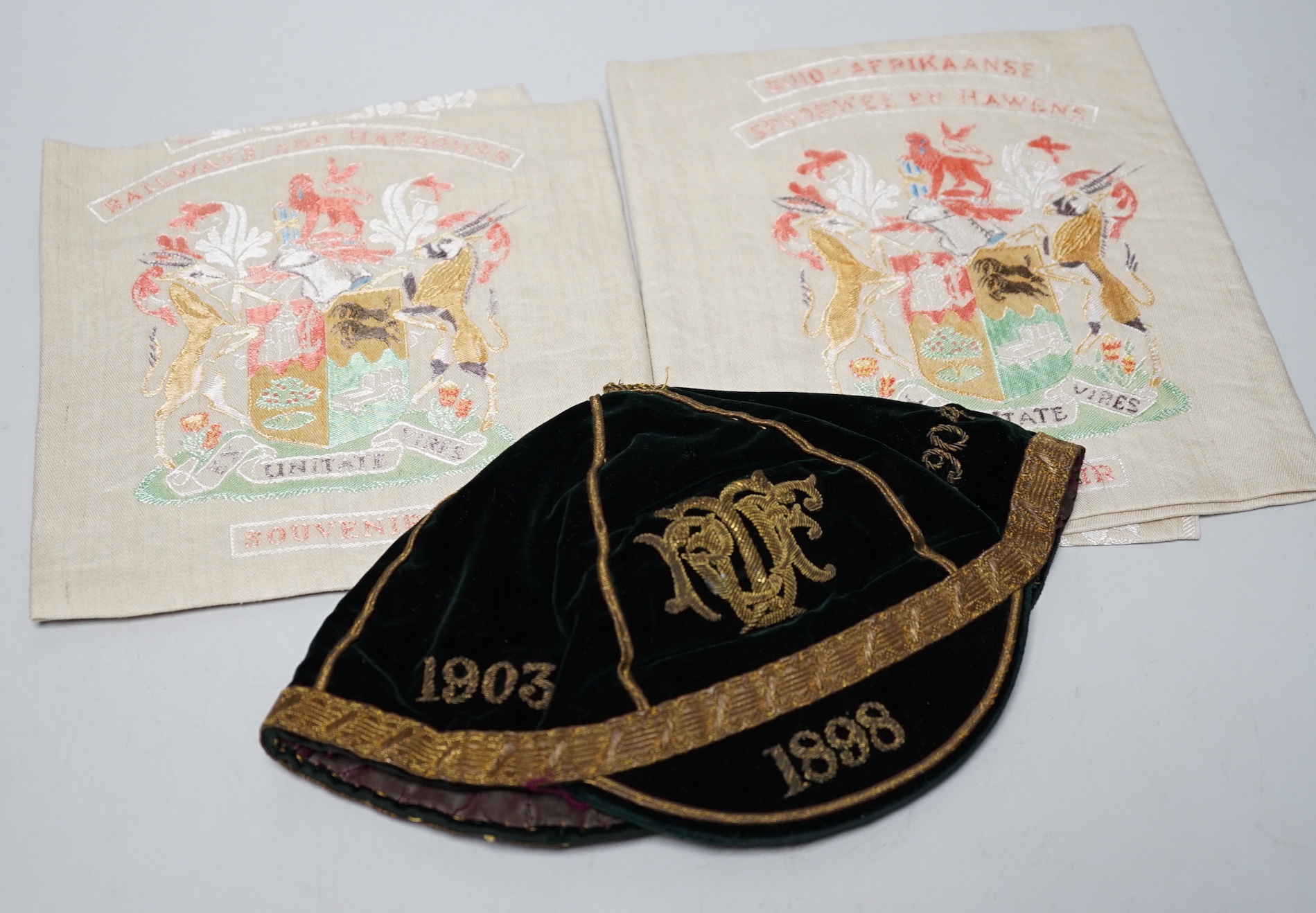 Two South African late 19th century damask railway napkins and a velvet rugby or cricketing cap                                                                                                                             
