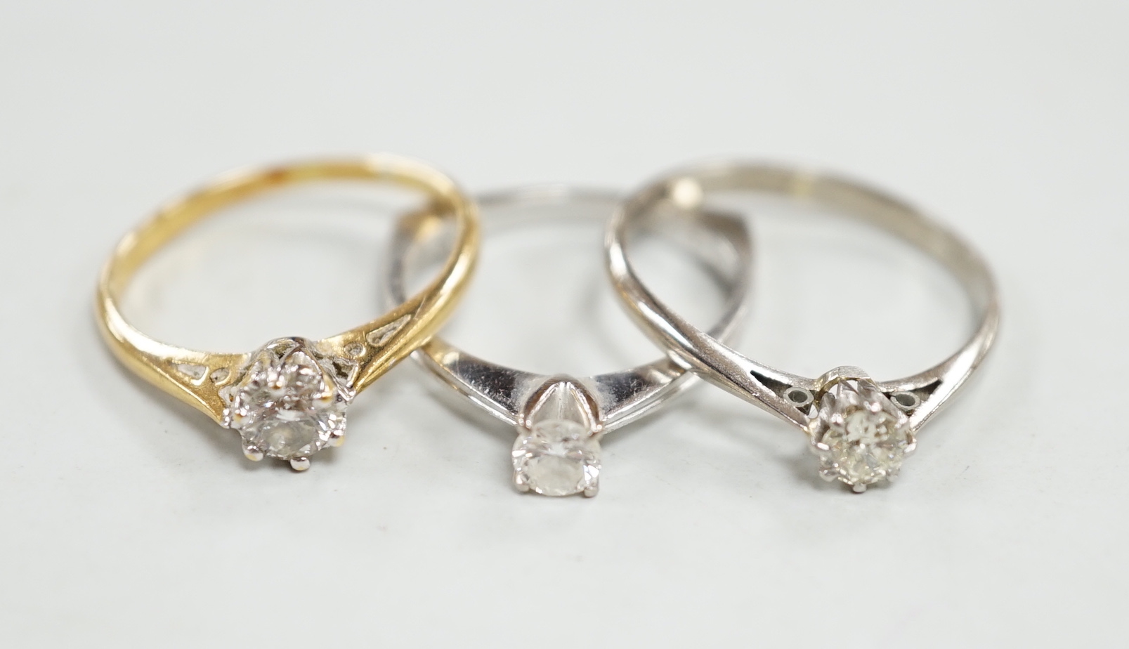 Three assorted 18ct and solitaire diamond rings, including one with 0.25ct stone, sizes J/K, M & N, gross weight 6.9 grams.                                                                                                 