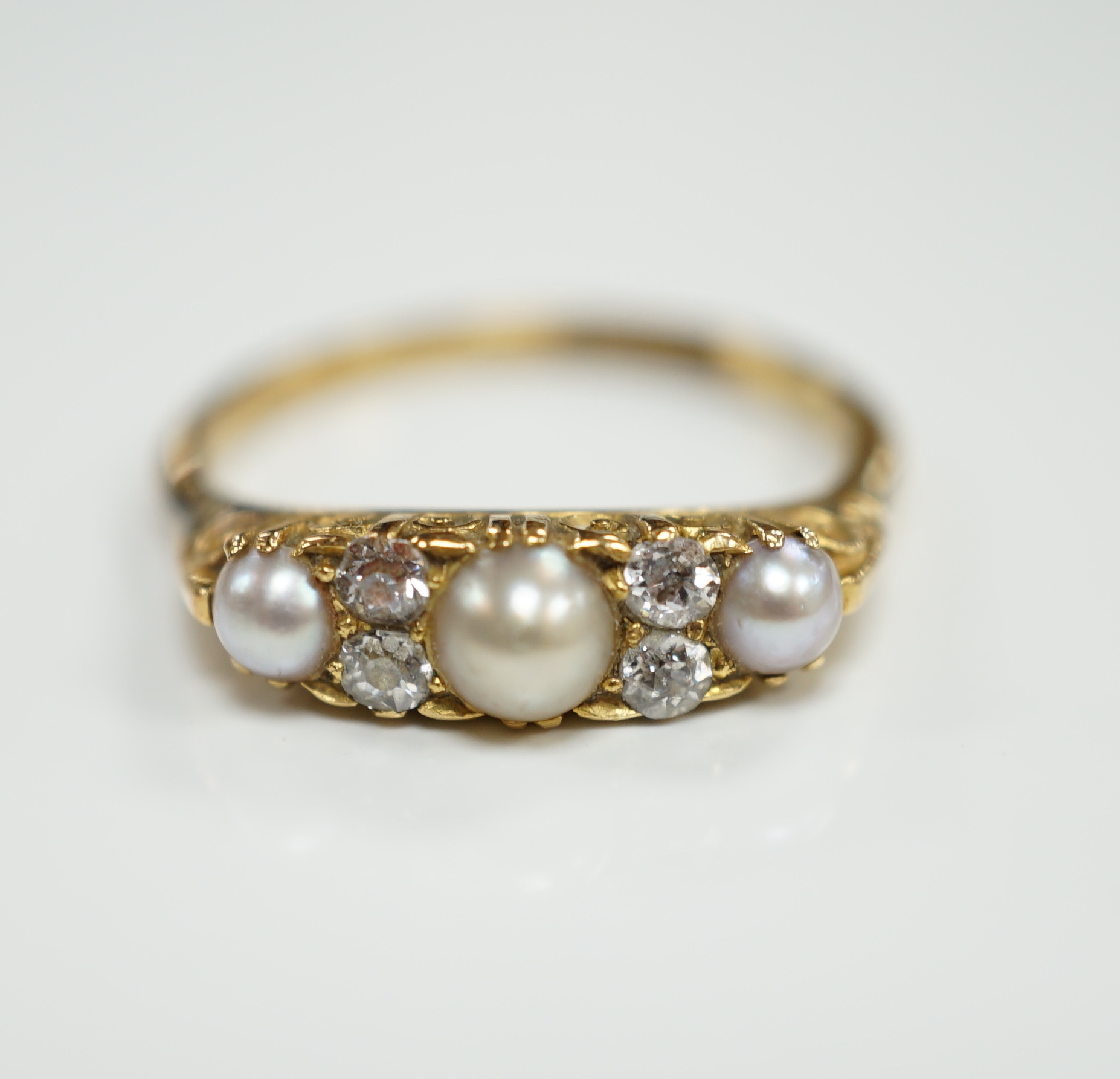 An early 20th century 18ct and plat, three stone split pearl and four stone diamond set half hoop ring, size P, gross weight 3.2 grams.                                                                                     