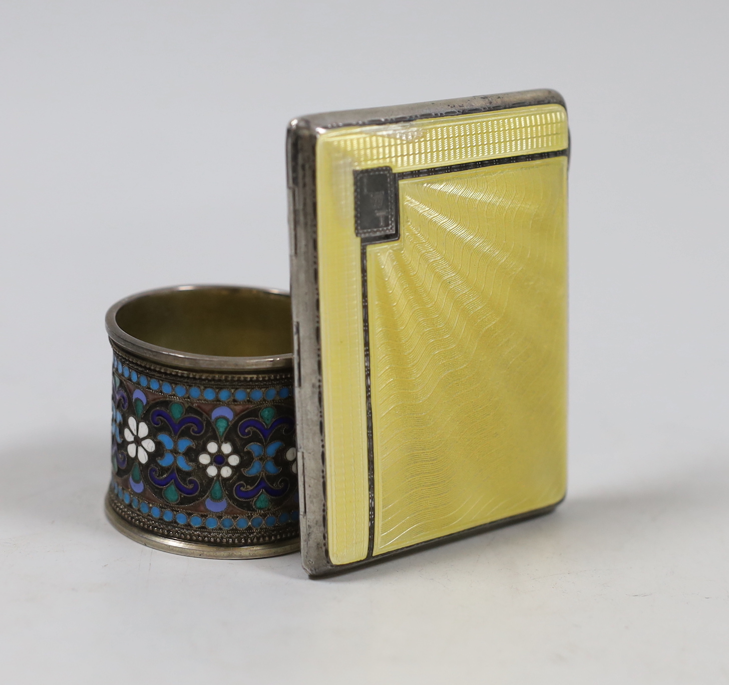 A George V silver and enamelled cigarette case, Birmingham, 1935, 85mm and an early 20th century Russian 84 zolotnik and cloisonné enamelled napkin ring.                                                                   