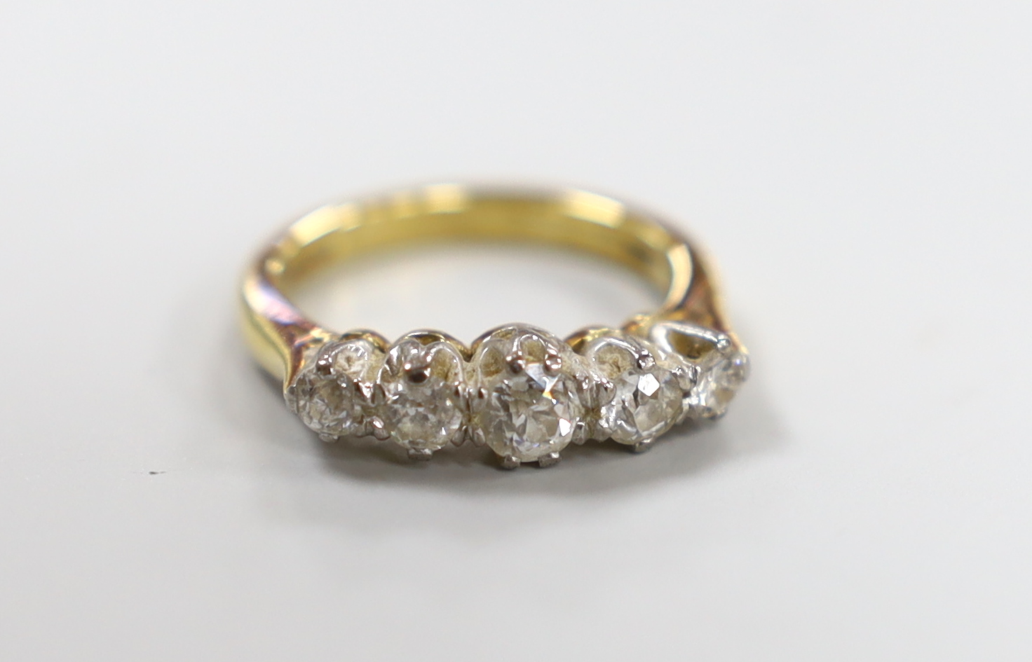 A modern 18ct gold and graduated five stone diamond set half hoop ring, size J, gross weight 3.9 grams.                                                                                                                     