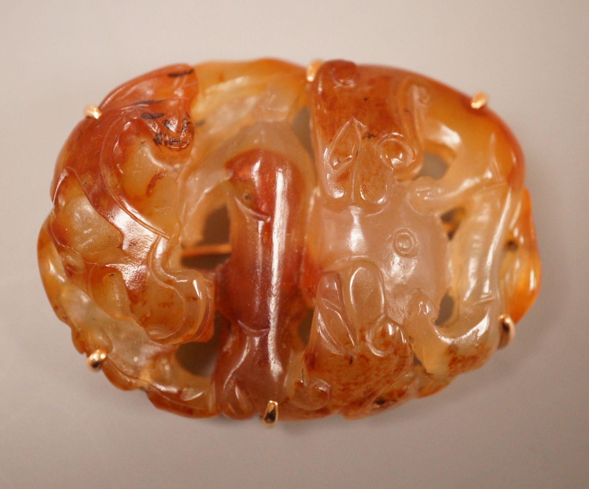A Chinese carved agate plaque, Qing dynasty, later mounted as a brooch, 5.5cm long                                                                                                                                          