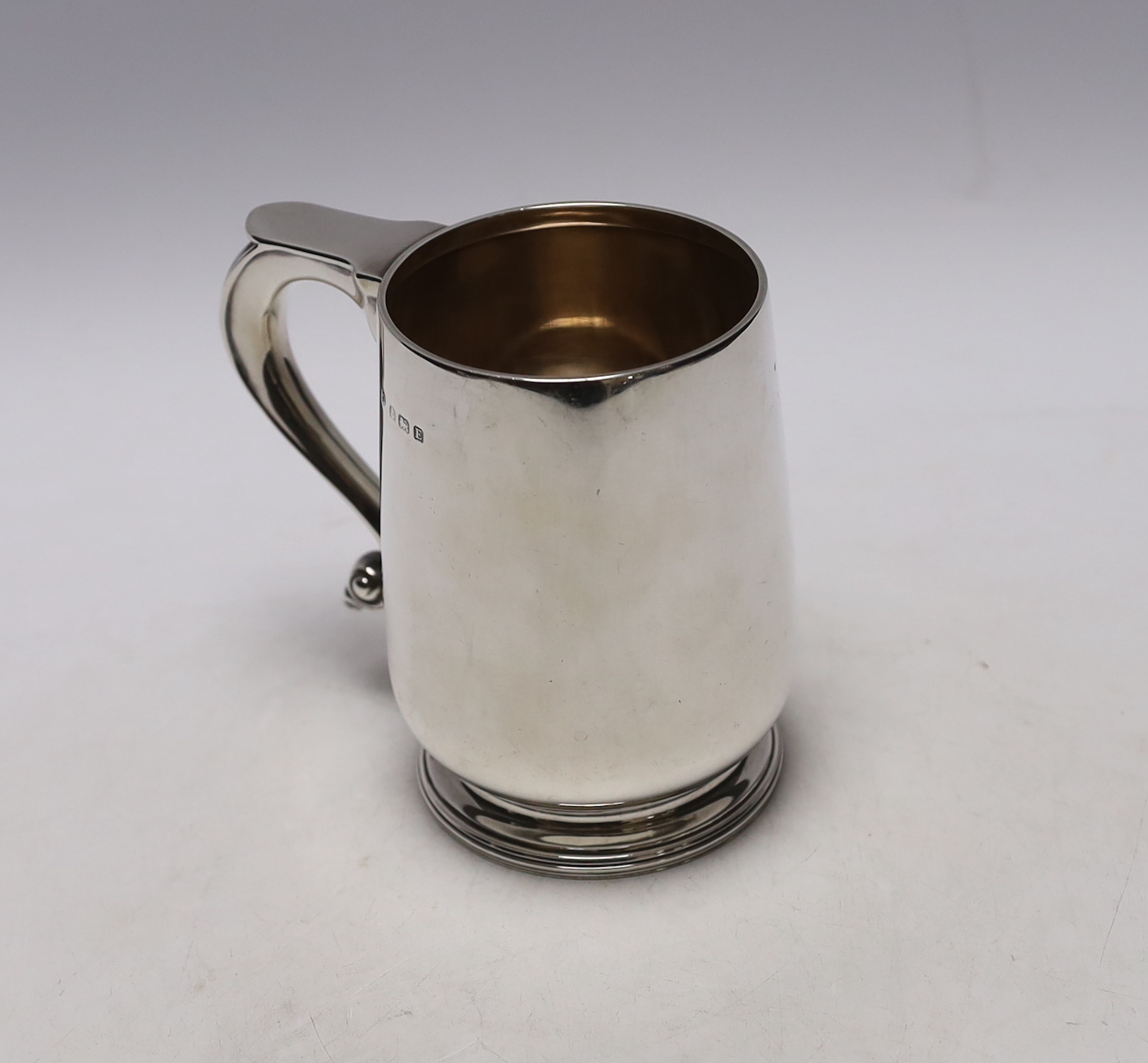 A George V silver mug, by William Neale Ltd, Birmingham, 1929, 11.9cm, 11oz.                                                                                                                                                