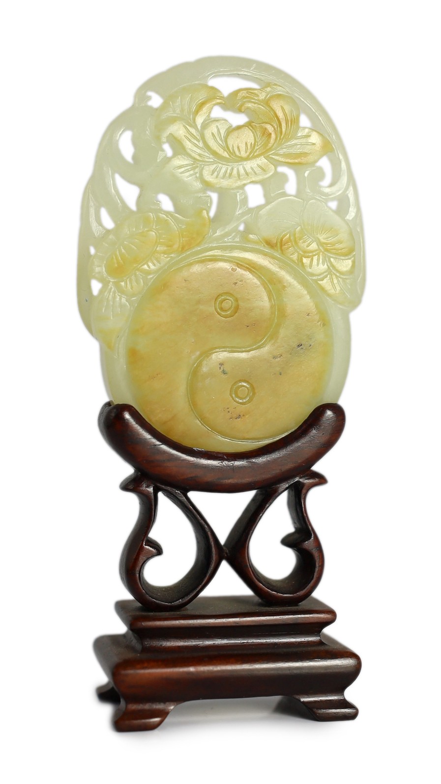 A Chinese white and russet skin jade oval plaque, 19th century, 6.4cm, wood stand                                                                                                                                           